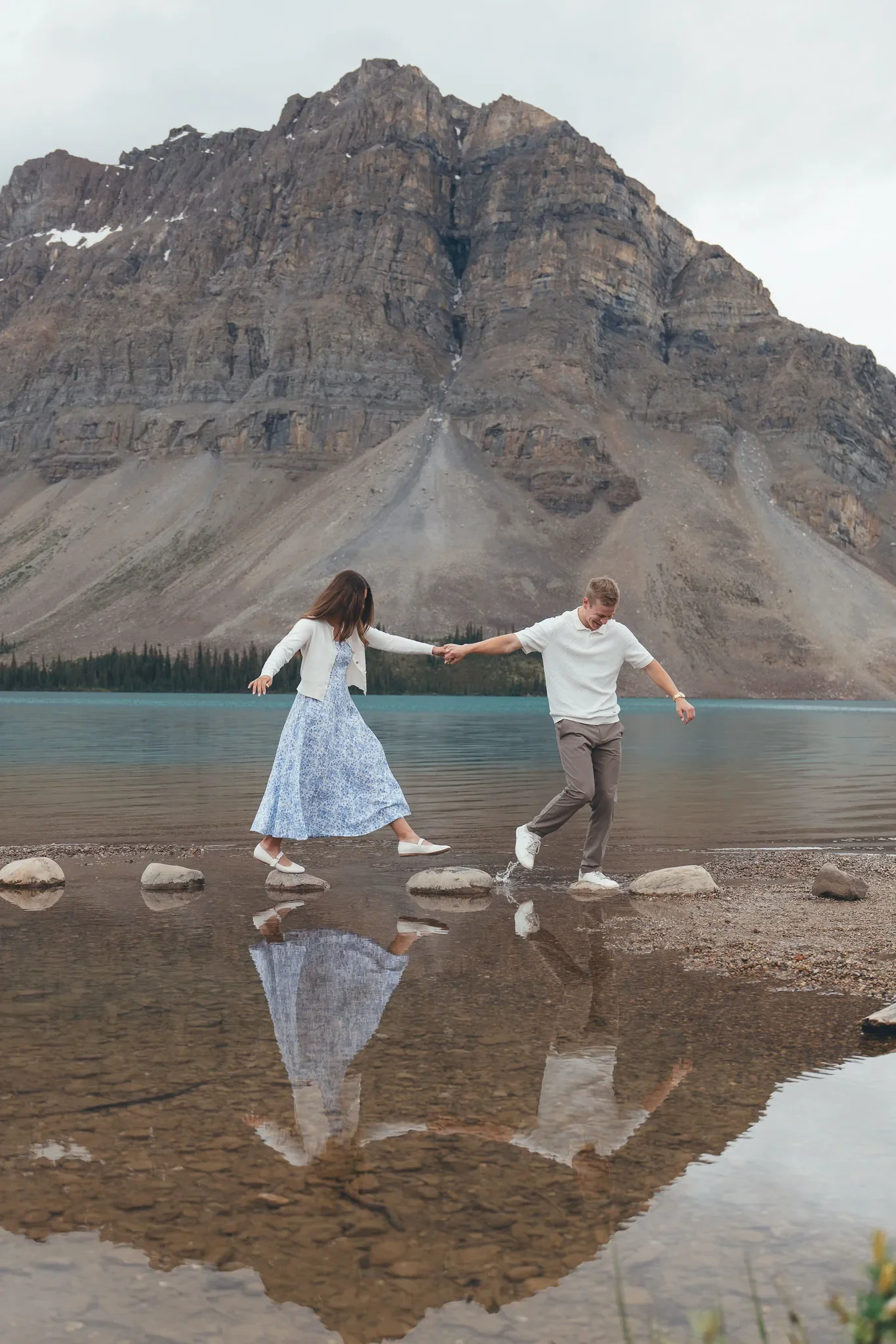 138_couple-walking-stepping-stones-alpine-lake-canadian-rockies.webp