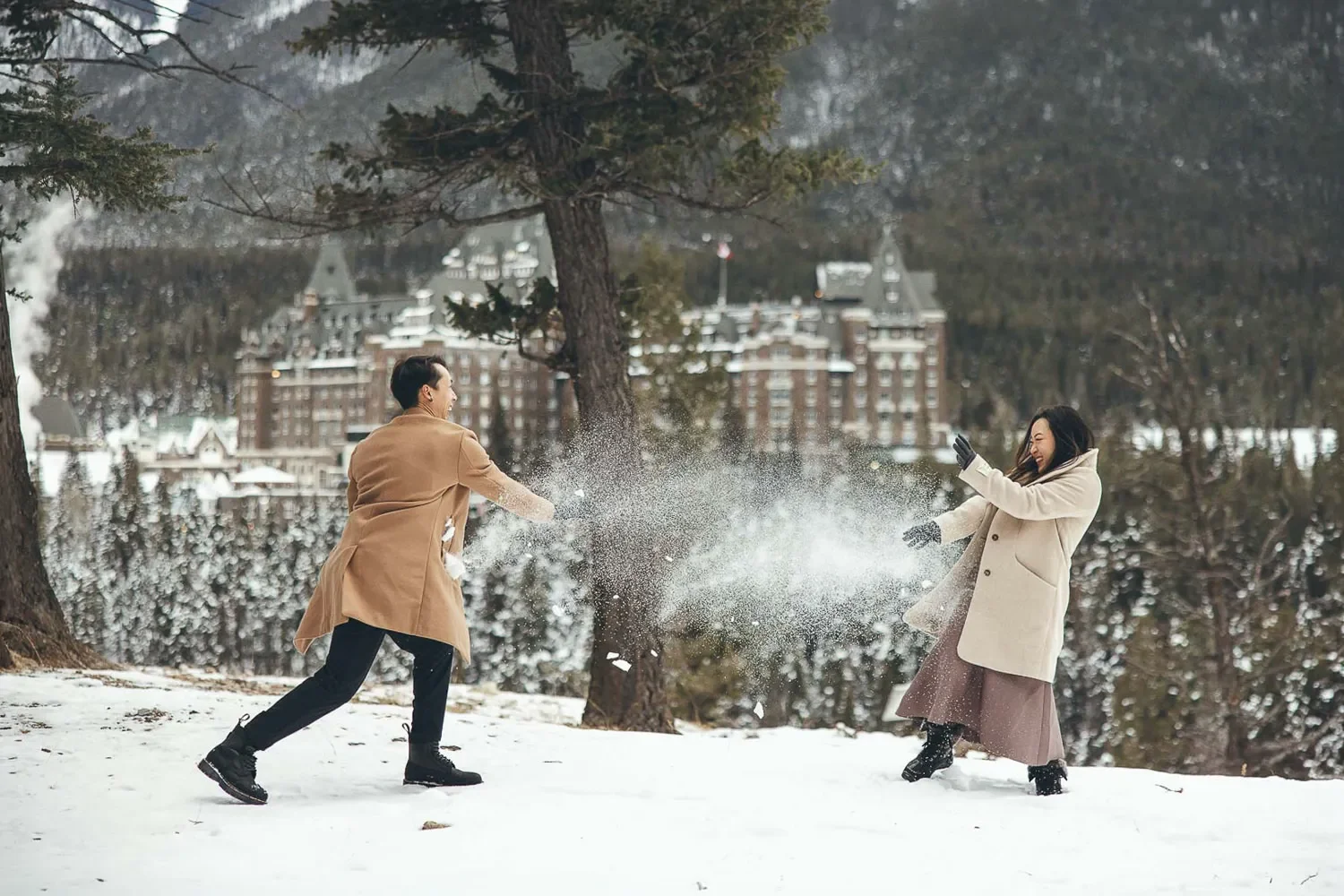 124_couple-playing-in-snow-Fairmont-Banff-Springs-winter-portrait.webp