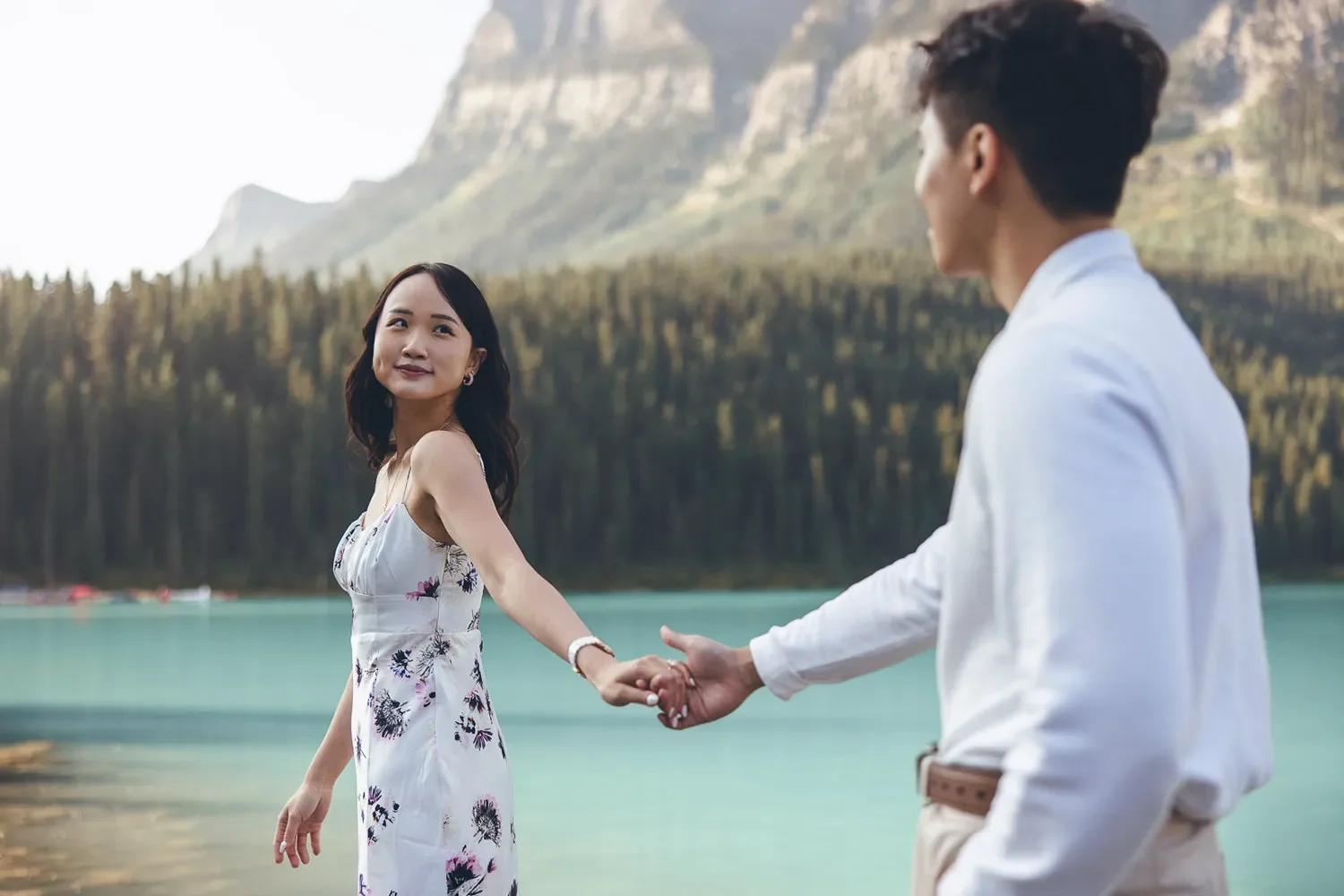 115_couple-holding-hands-engagement-lake-louise-banff-mountain-landscape.webp