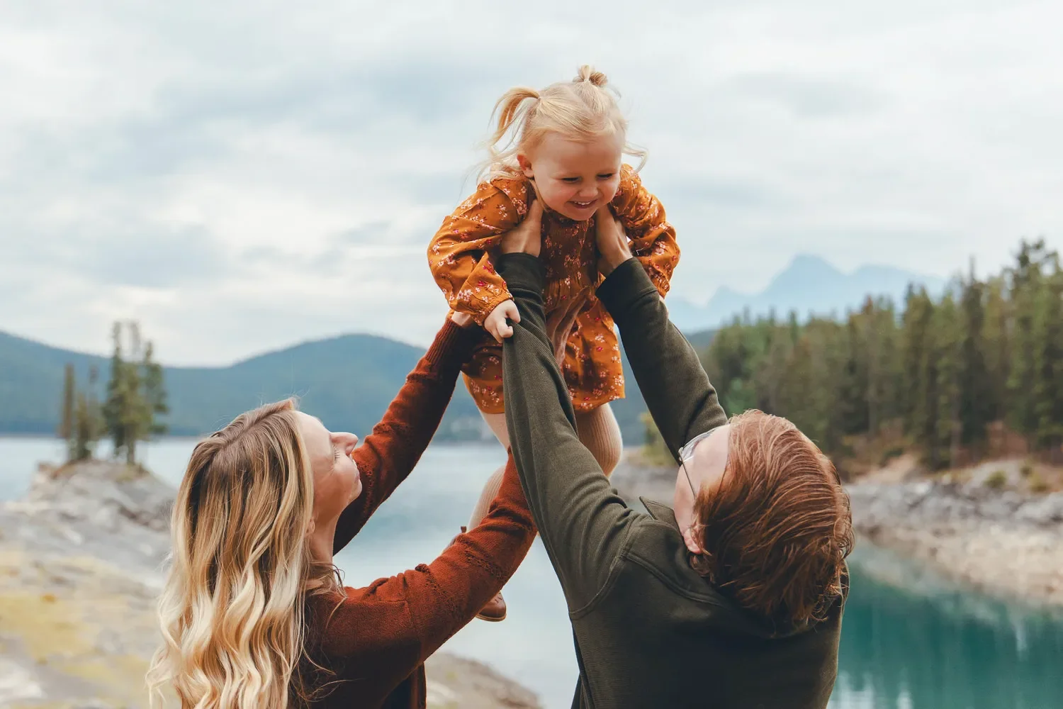 113_Family-Portrait-Parents-Lifting-Child-Canadian-Rockies-Lake.webp