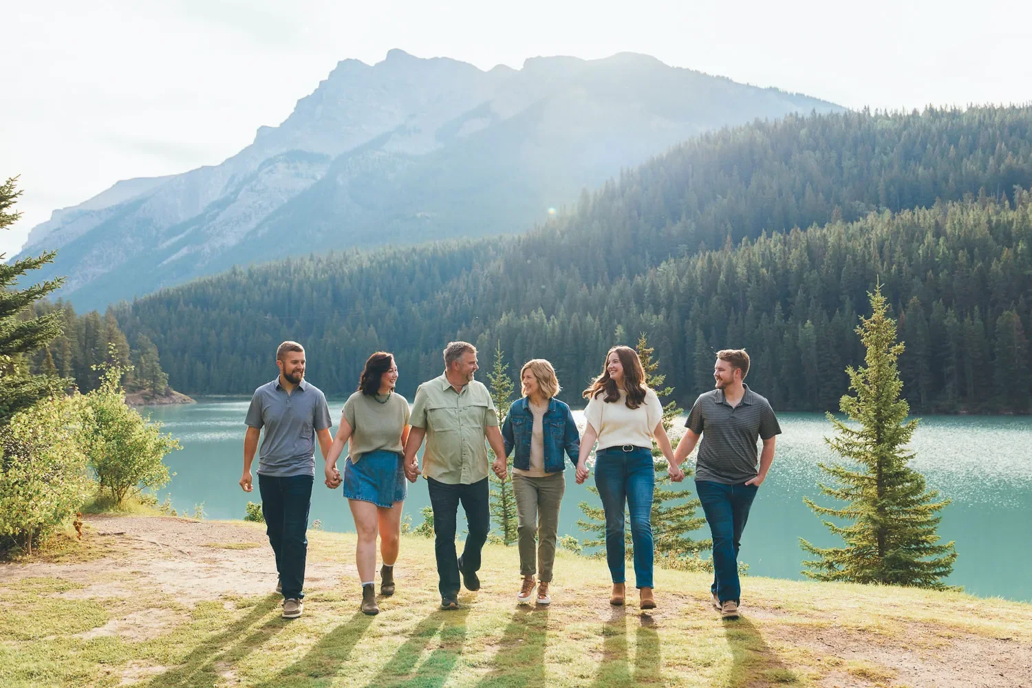 124_Family-Portrait-Walking-Hand-In-Hand-Banff-Mountain-Lake.webp