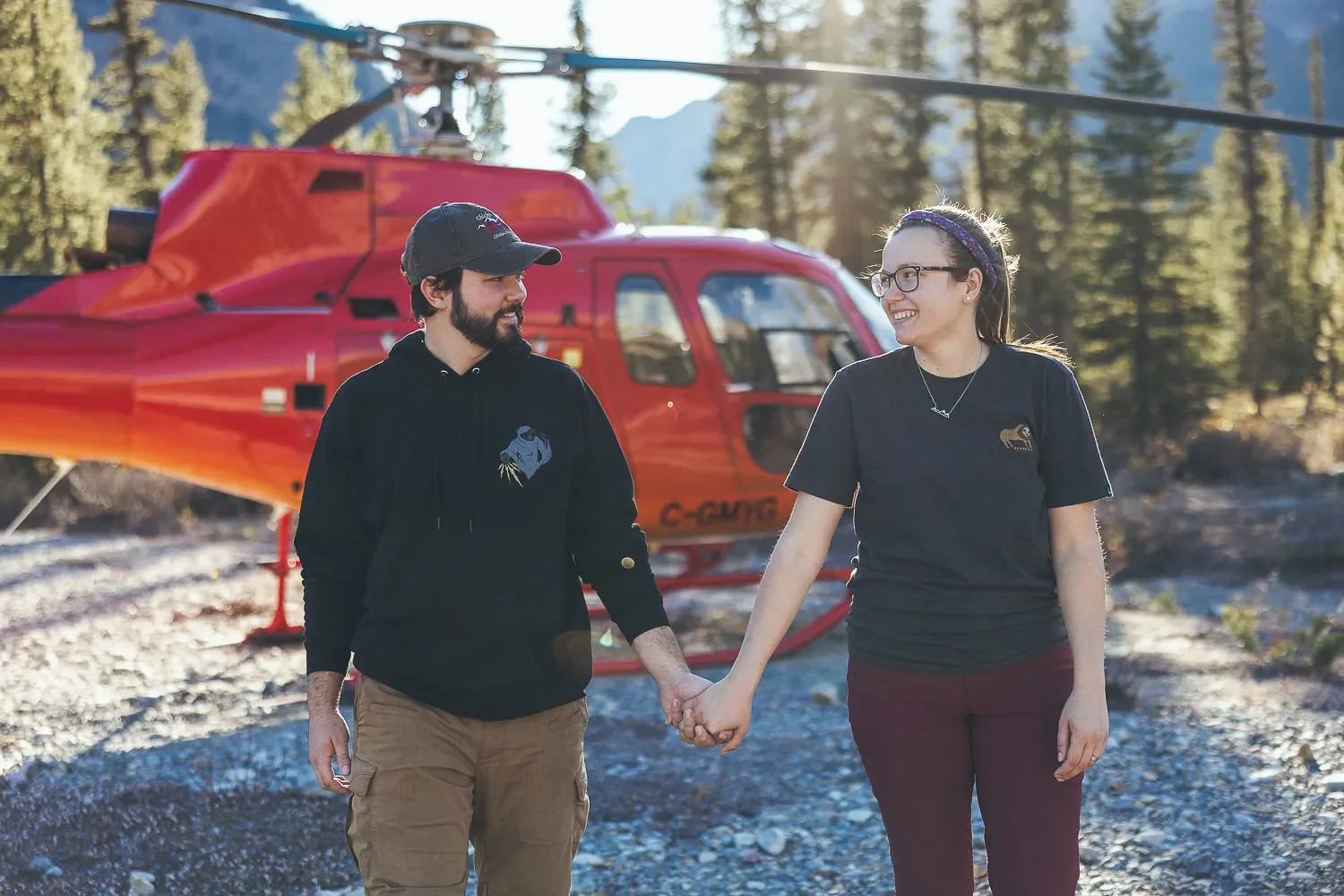 105_Couple-Walking-Holding-Hands-Red-Helicopter-Canadian-Rockies.webp