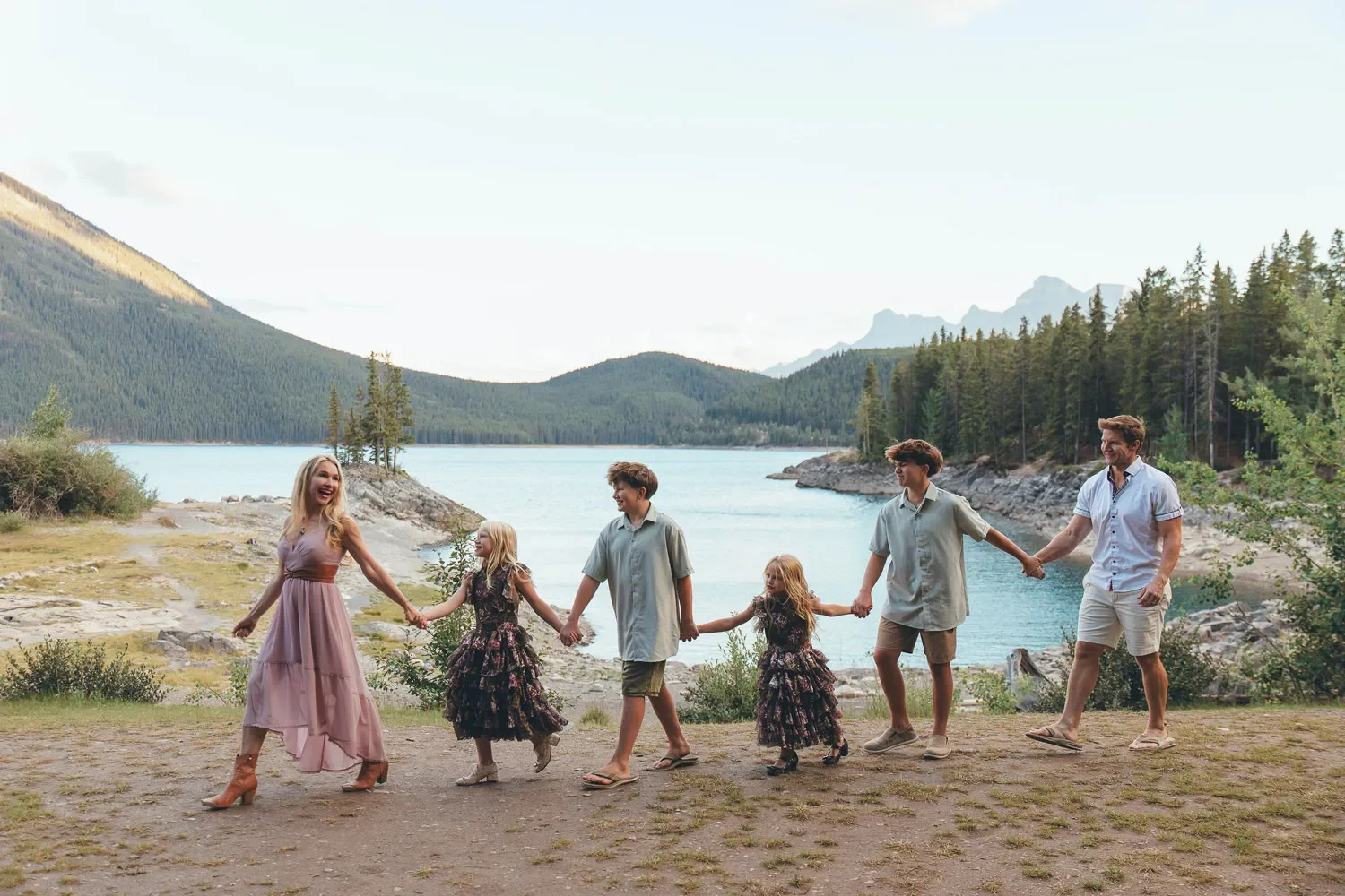 112_Family-Walking-Holding-Hands-Alpine-Lake-Canadian-Rockies.webp