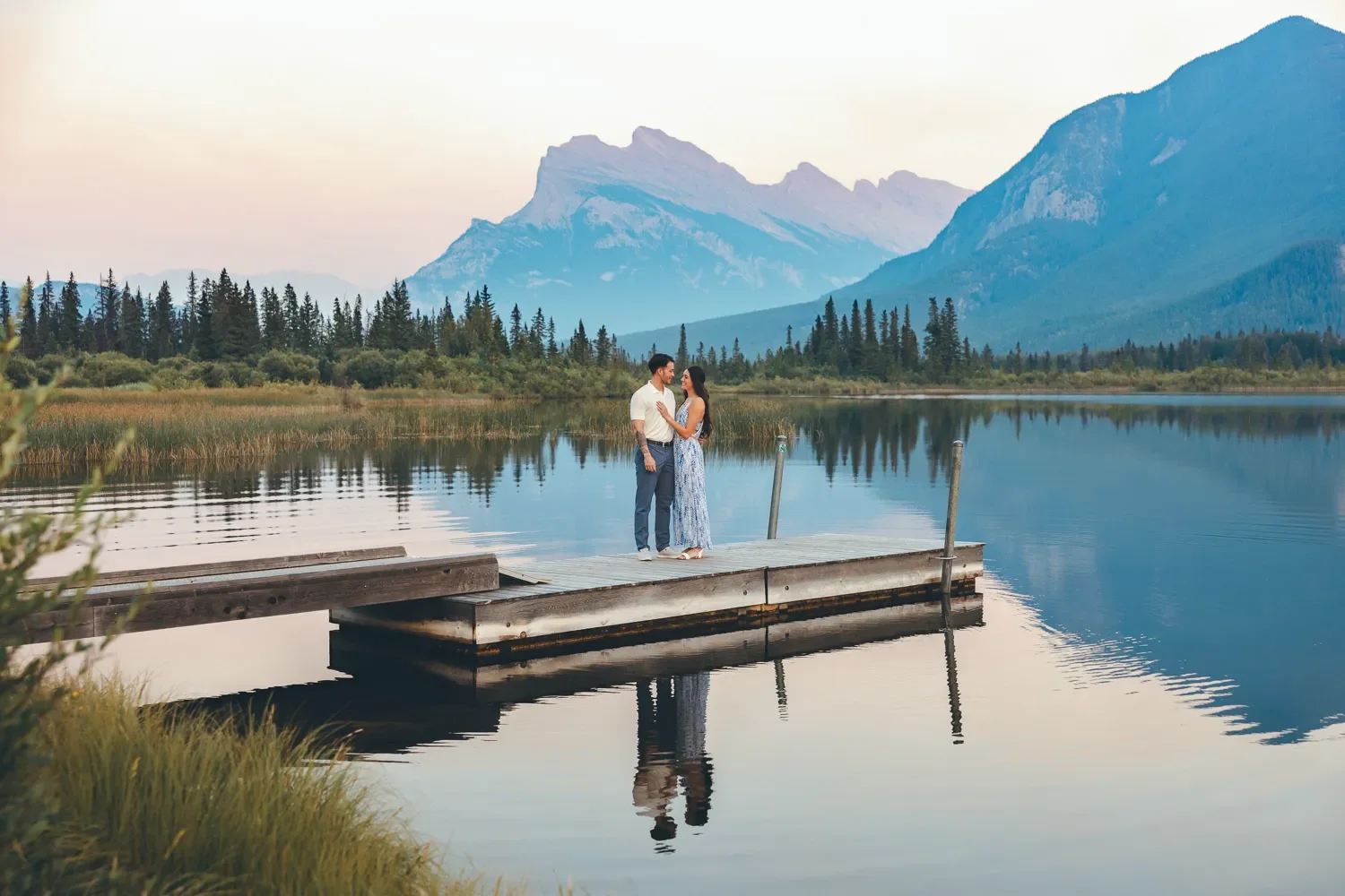 114_Couple-Standing-On-Dock-At-Banff-Mountain-Lake-At-Sunset.webp