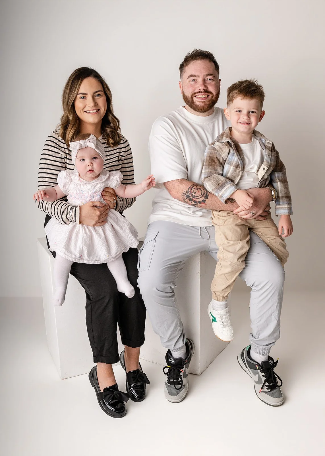 Family of four in photography studio: mum, dad, young boy of 4, and baby of 5 months.