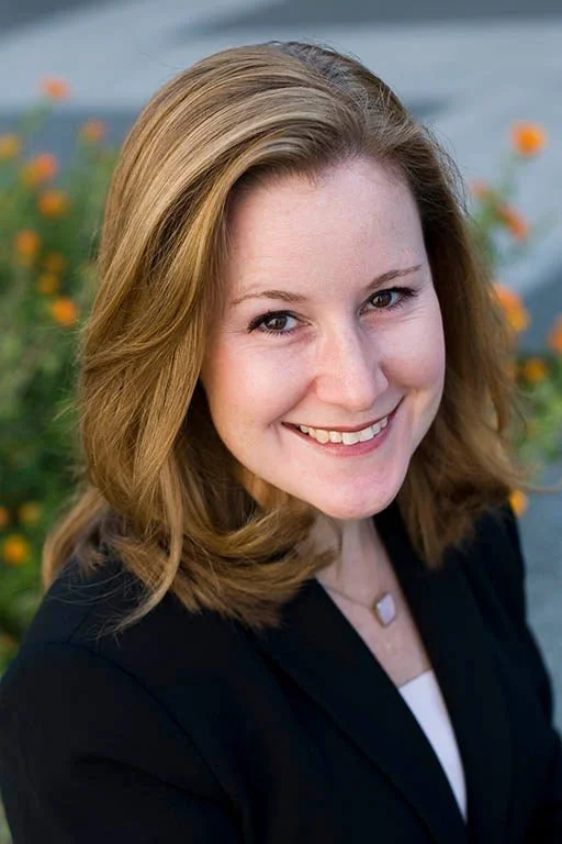 Dr. Catherine Weaver outside with orange flowers