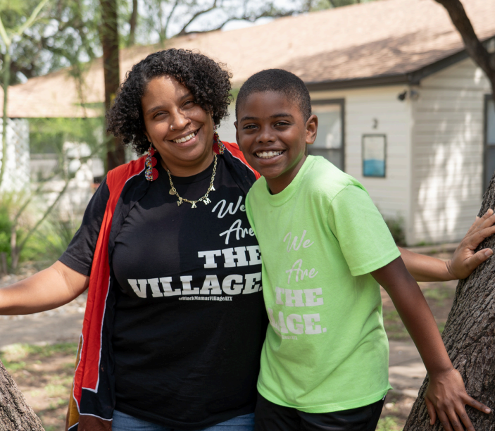 Smiling person in black/red top next to smiling youth in lime green shirt in front of beige building