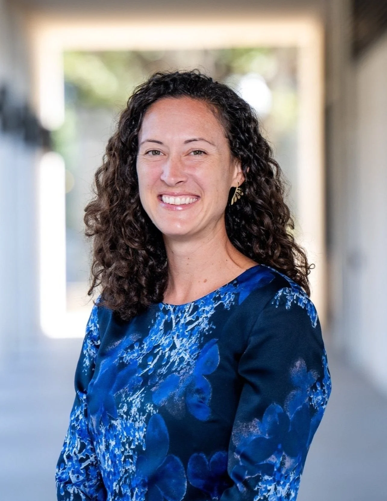 Dr. Natalie Poulos outside with illuminated square