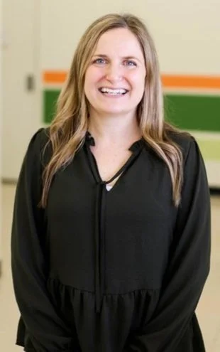 Alicia Jallah with beige, green, and orange wall in background