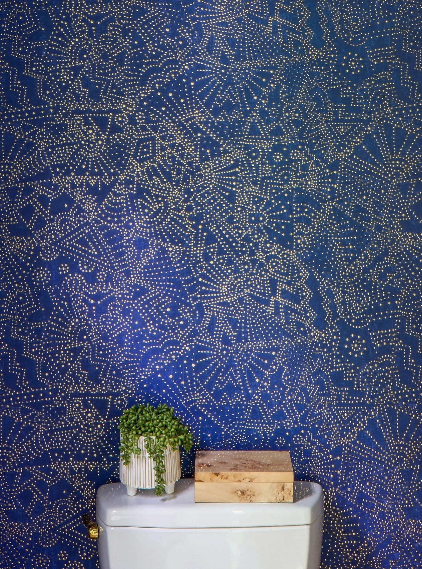This outdated Powder Room, with its awkward toilet placement, inefficient vanity, and lackluster d&eacute;cor, posed a real design challenge for our clients. The 'after' transformation reveals a stunning makeover featuring bold wallpaper, reconfigure