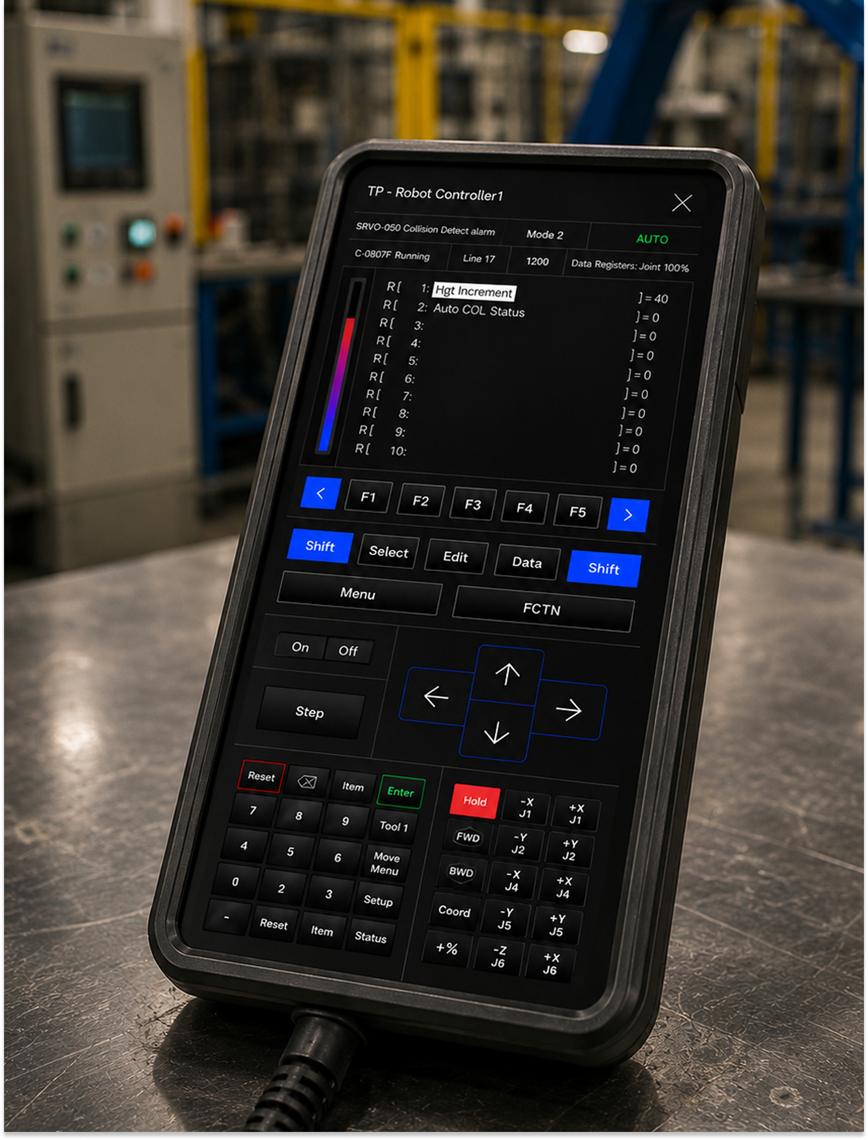 A handheld industrial control device with a digital display and keypad, connected to a cable, in a manufacturing or industrial setting.