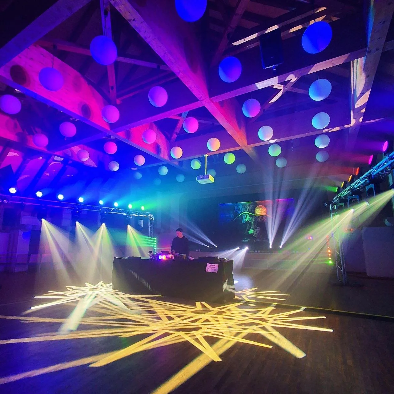 Bunte Lichter in einer Tanzhalle mit DJ im Mittelpunkt