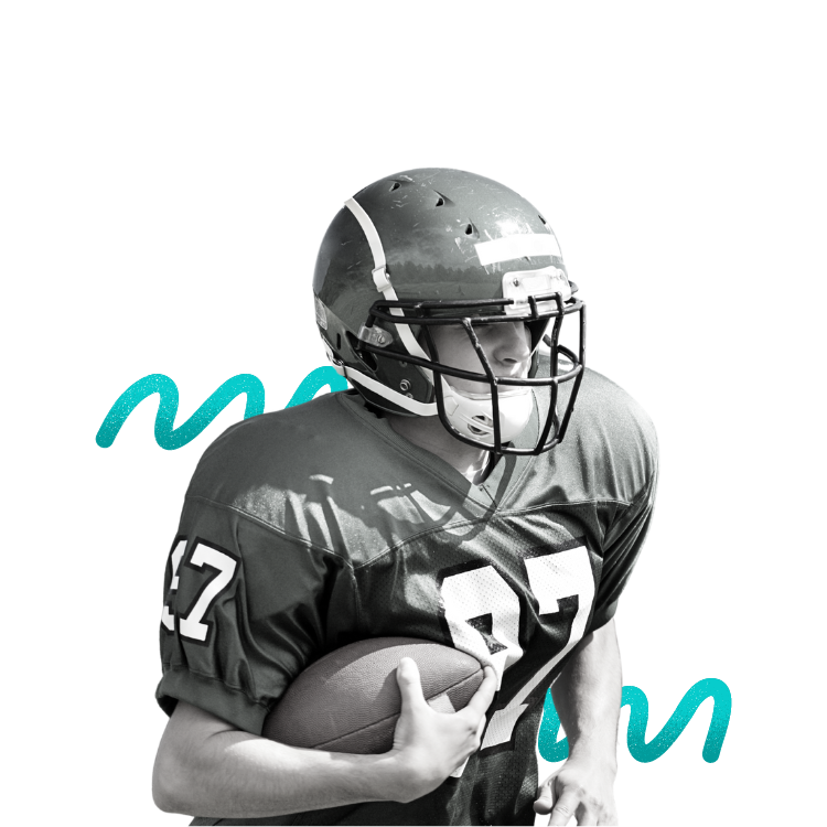 A football player wearing a helmet and uniform holding a football.