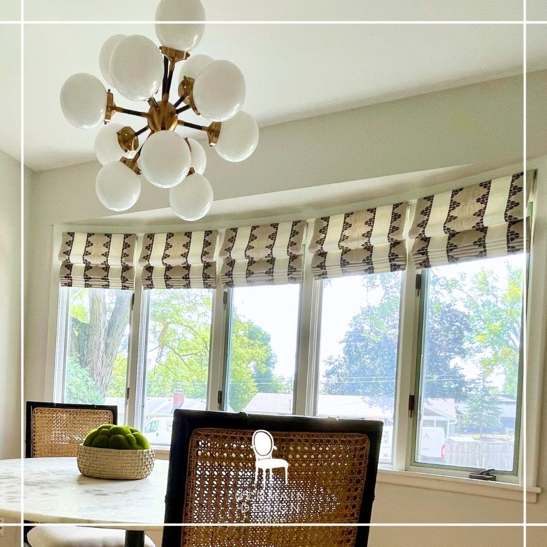🎉It's #TextileTuesday! ☀️ The afternoon sun streams through the bay window of this delightful dinette. To elevate the ambiance, we added a series of Roman shades in a timeless yet modern neutral print, and installed this fabulous statement light . E
