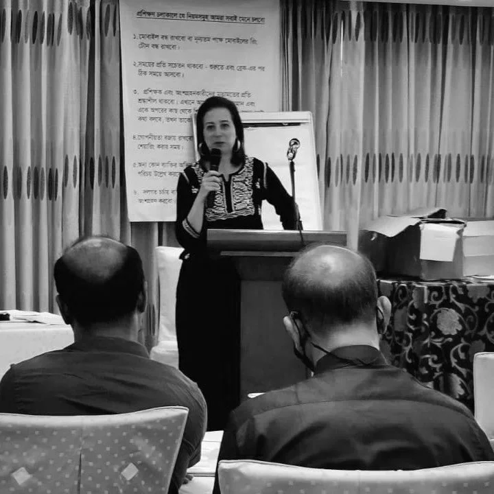 A picture of Vicki holding a microphone at a conference