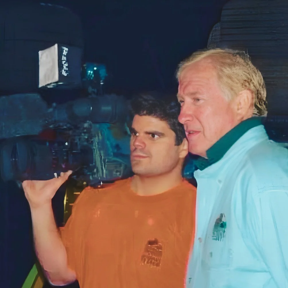 Damien Campbell holding a video camera and standing next next to another man