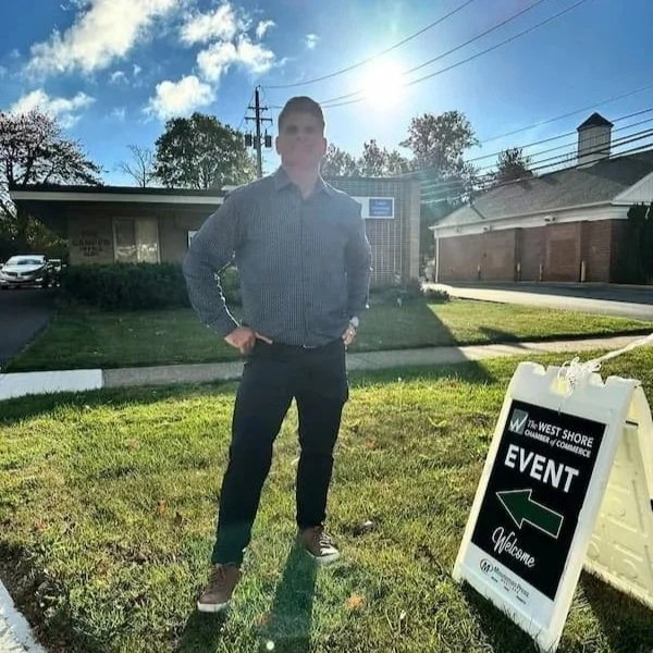 Damien Campbell standing outside on a sunny day in front of an office building.