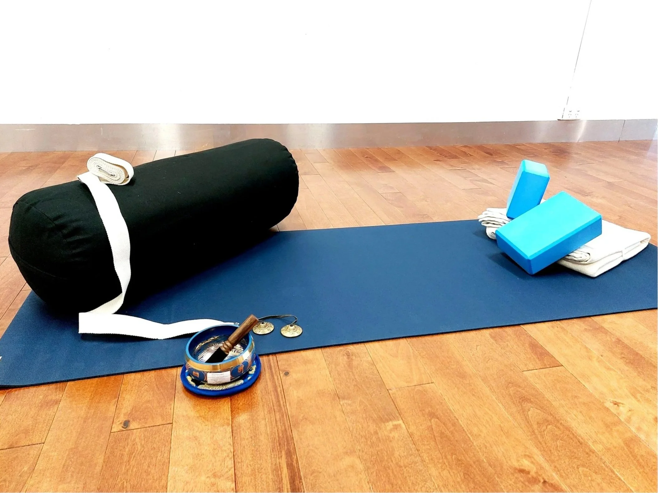 Yoga mat and props including bolster, blocks, blanket, strap, hand cymbols and small singing bowl