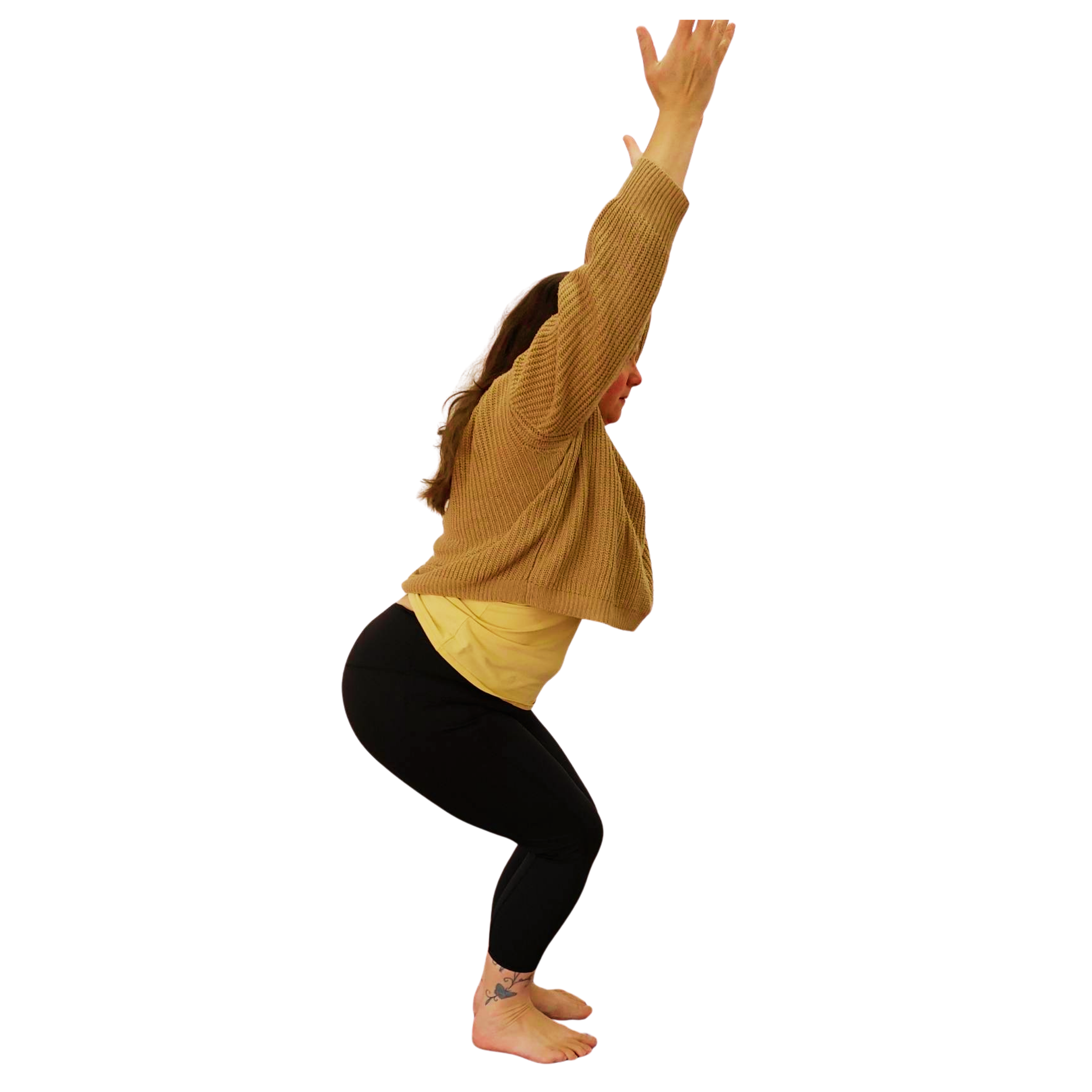 Woman wearing a loose jumper and black leggings in a yoga pose standing with both knees bent and arms raised overhead