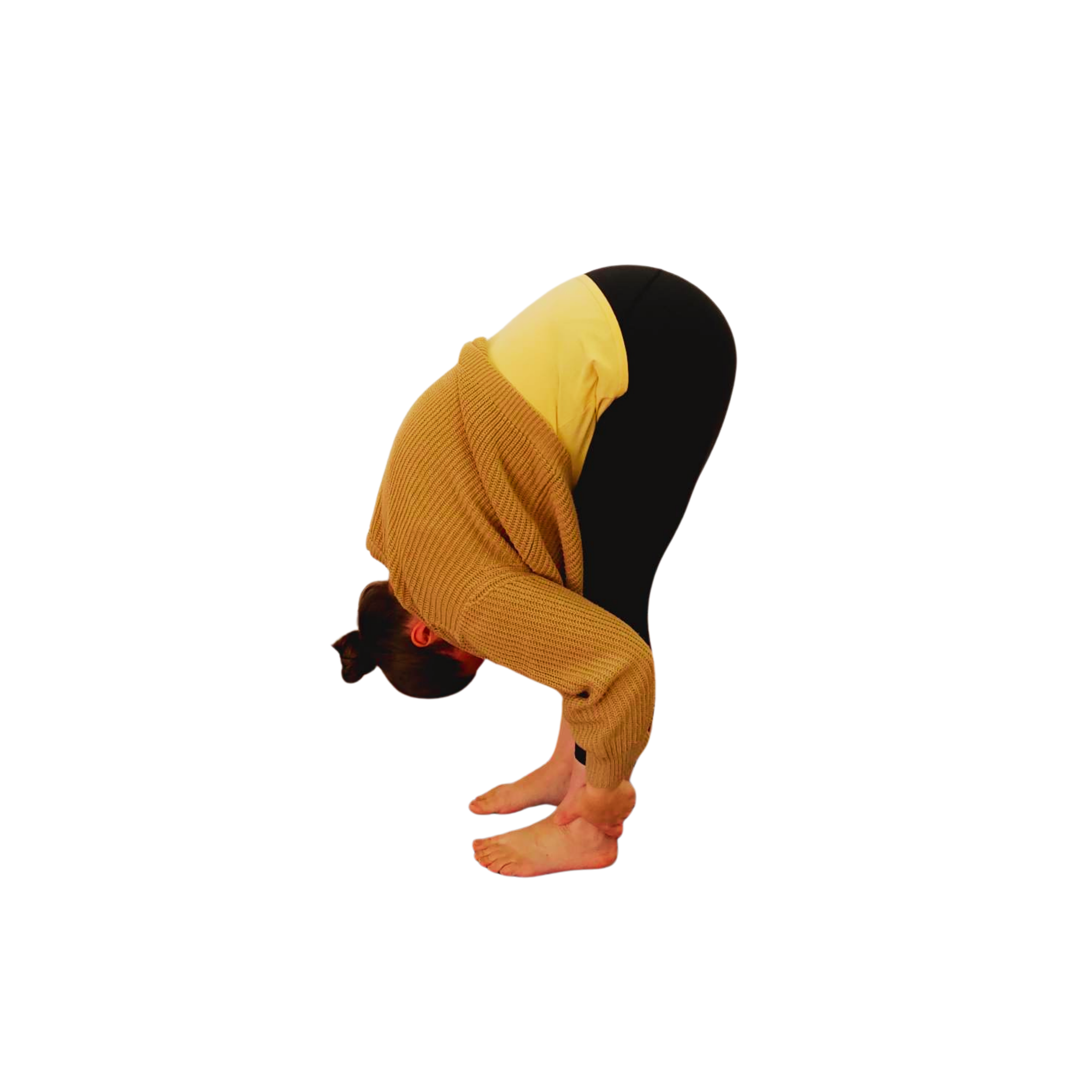 Woman wearing a loose jumper and black leggings in a yoga pose folding forward at the waist with the head down and holding onto the ankles