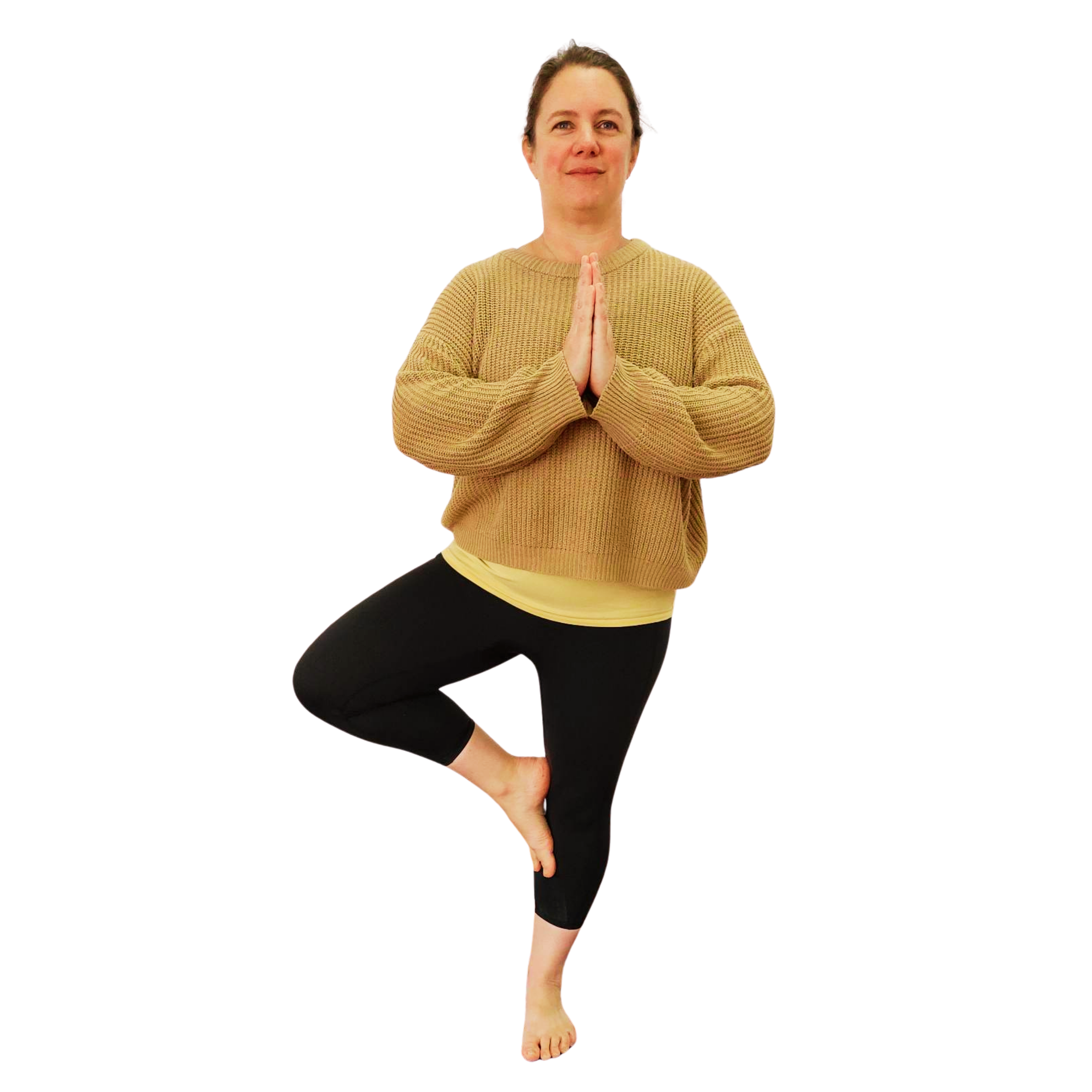 Woman wearing a loose jumper and black leggings in a yoga pose standing on one leg with the other knee pointed out to the side and the foot pressing into the standing leg, hands together in front of the chest