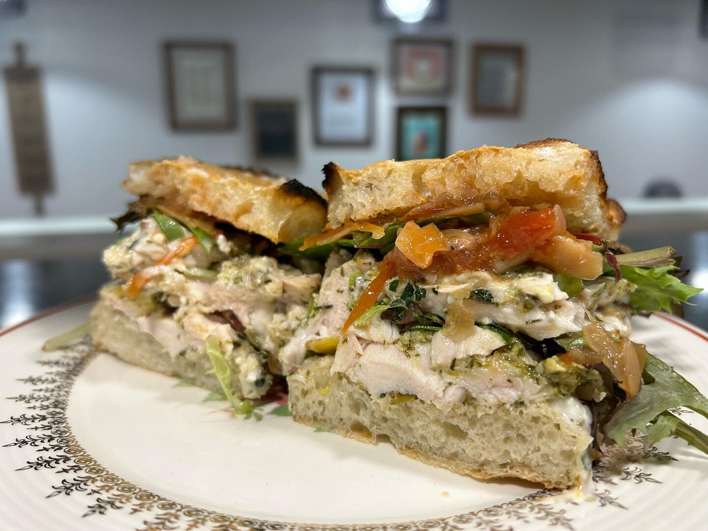 These chickens crossed the road to get dressed up Greek 🐓
On Focaccia we&rsquo;ve got dill and lemon marinated chicken breasts. Topped off with tomato jam, olive and caper tapenade, lemon feta aioli and some greens. 
 Today and Tomorrow while suppli
