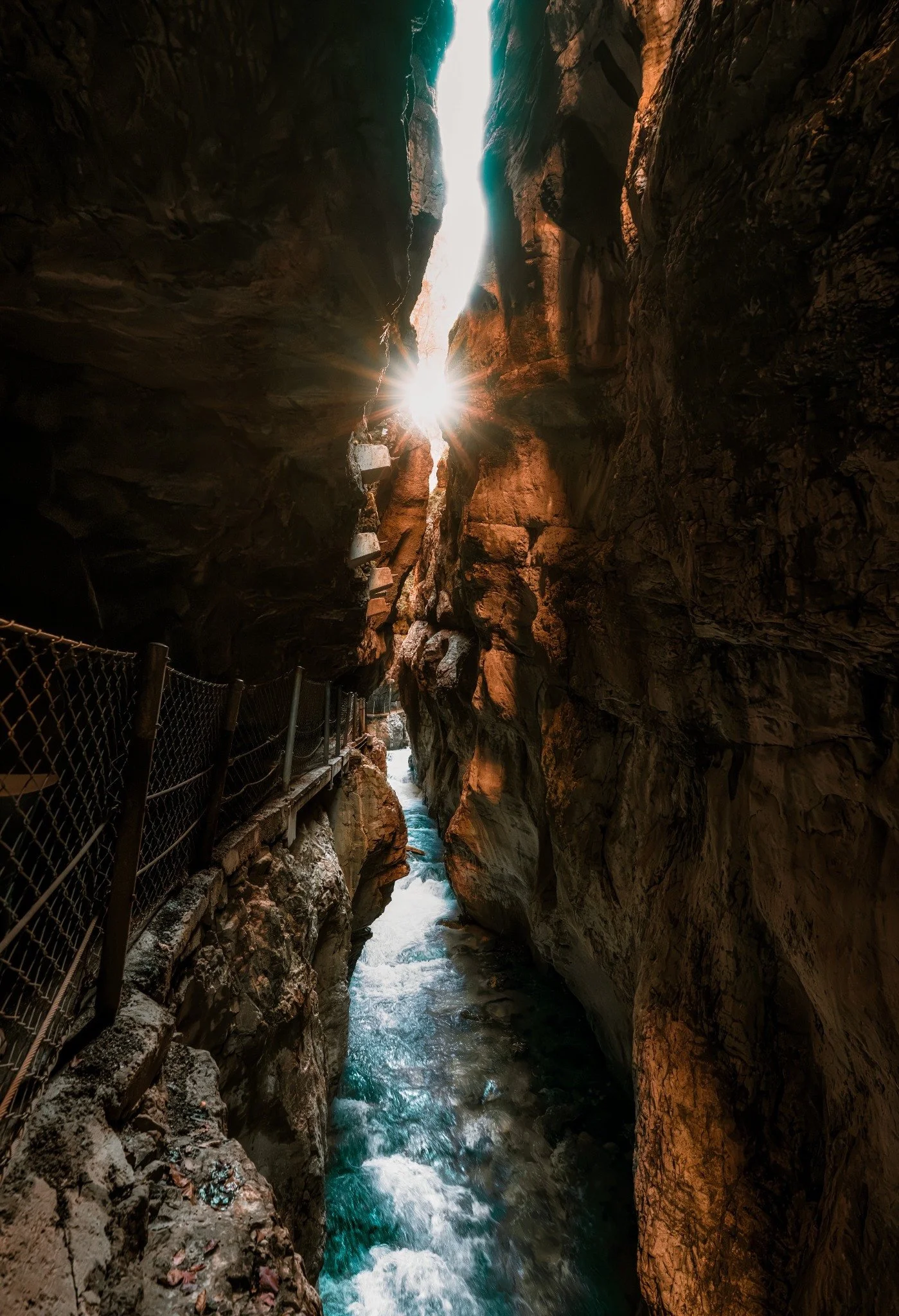 Sunburst shining between the steep rock walls of Partnach Gorge above the river.
