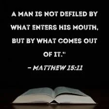 A black background with white text of a Bible verse from Matthew 15:11 about the importance of speech, and an open Bible at the bottom.