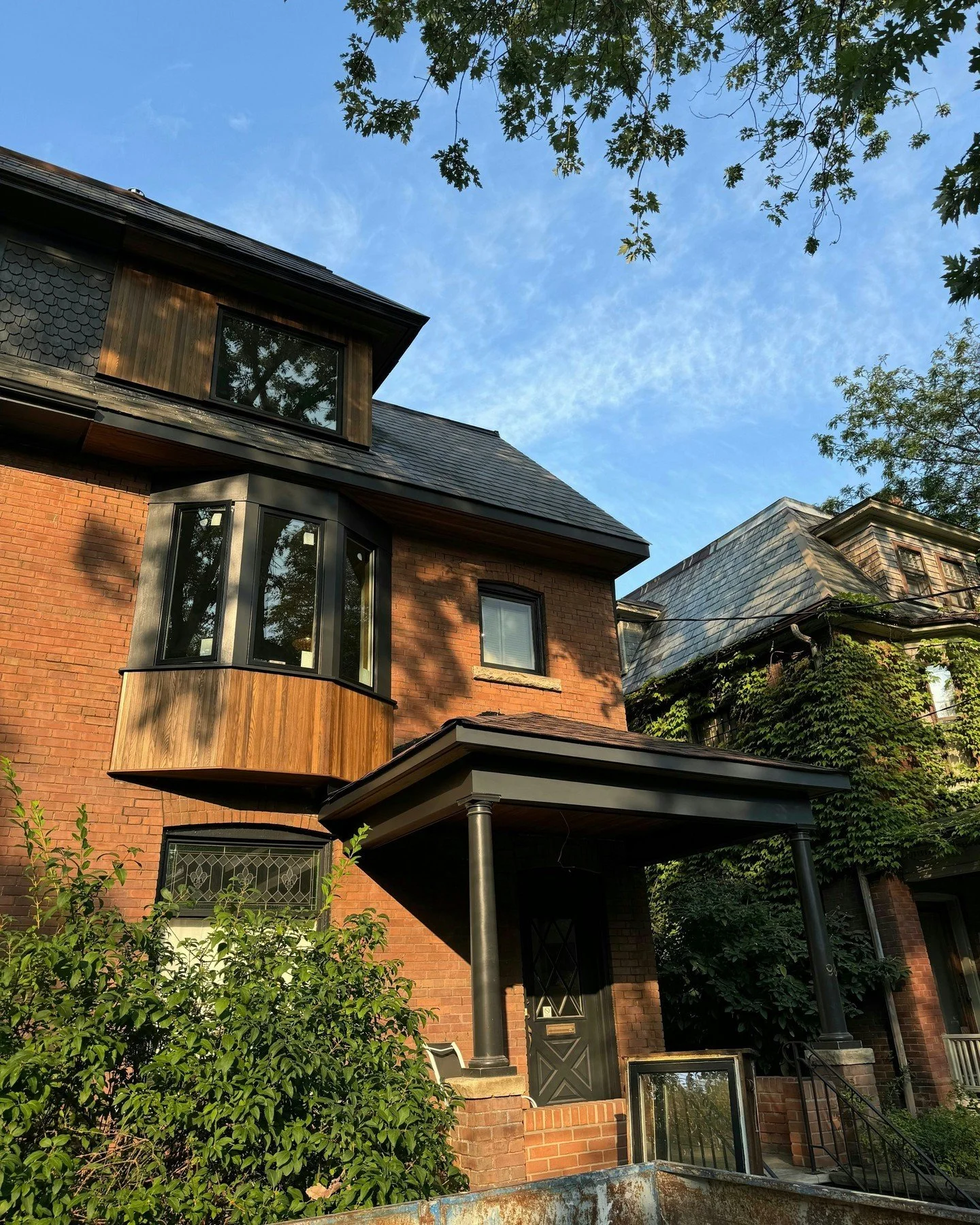 We gave this property some curb appeal with a newly framed bay window, new windows and added thermory Ais to exterior and front porch as well as painting. The black window trim and clean wood accents give this home a sleek and modern look. Swipe to s