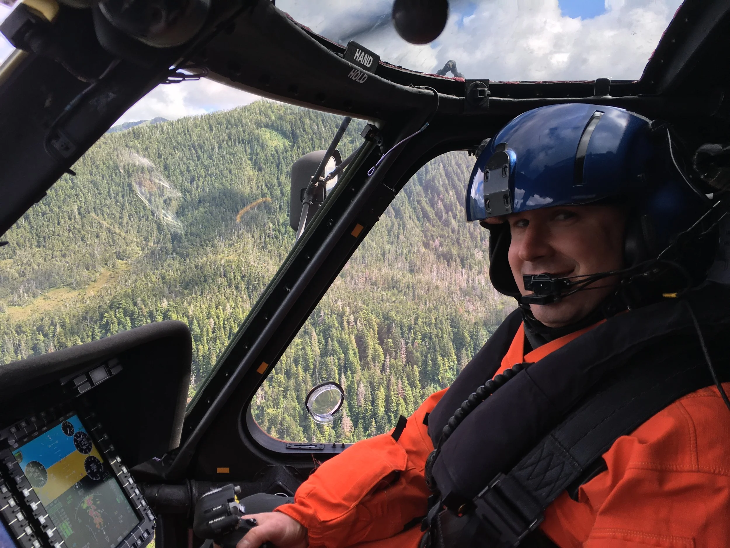 John flying a helicopter over Alaska while in serving in the USCG