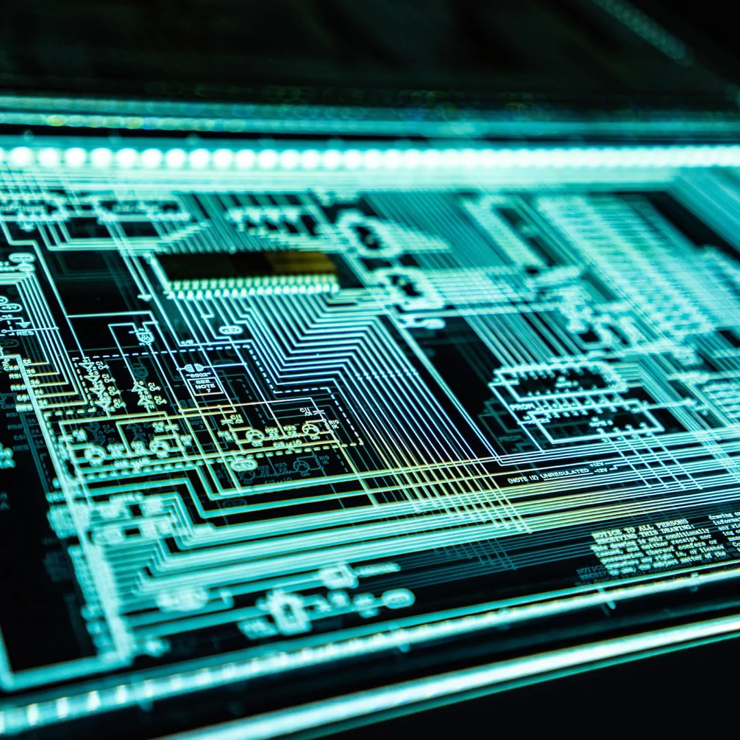 Close-up of a glowing computer circuit board with interconnected lines and components, showcasing a complex technological pattern.