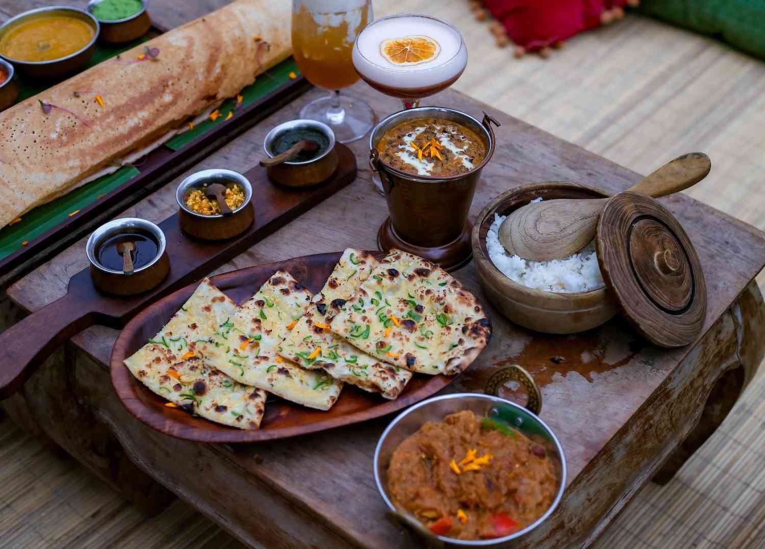 Authentic Indian cuisine at Pesona Lounge Trawangan featuring naan bread, dosa, curry dishes, rice, and signature beverages.