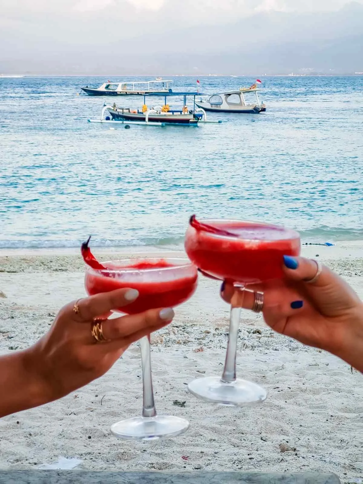 Two handcrafted signature cocktails served at Pesona Lounge Trawangan with a beachfront view.