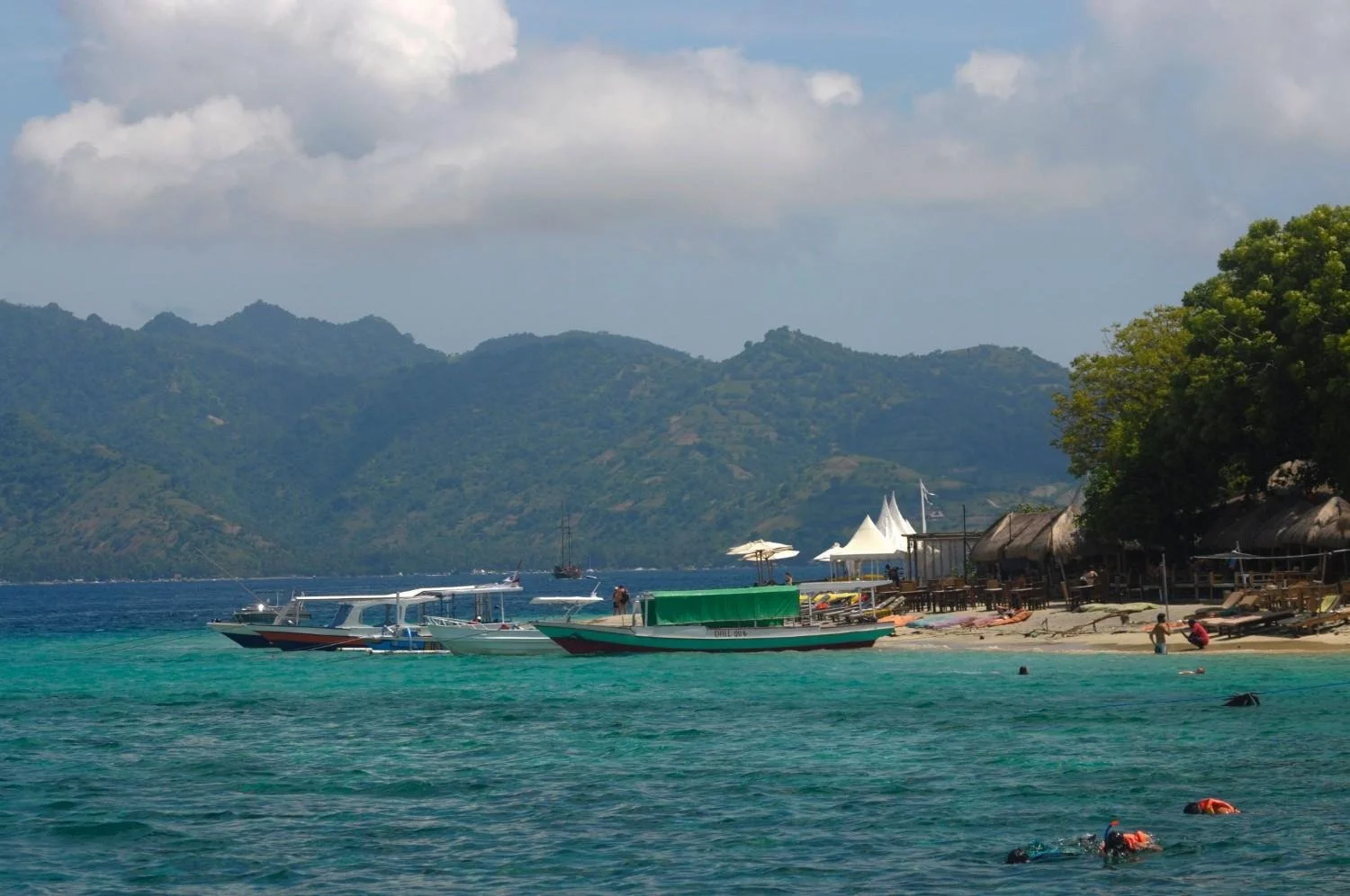 Travellers relaxing on the beach while enjoying the tropical atmosphere of Gili Trawangan