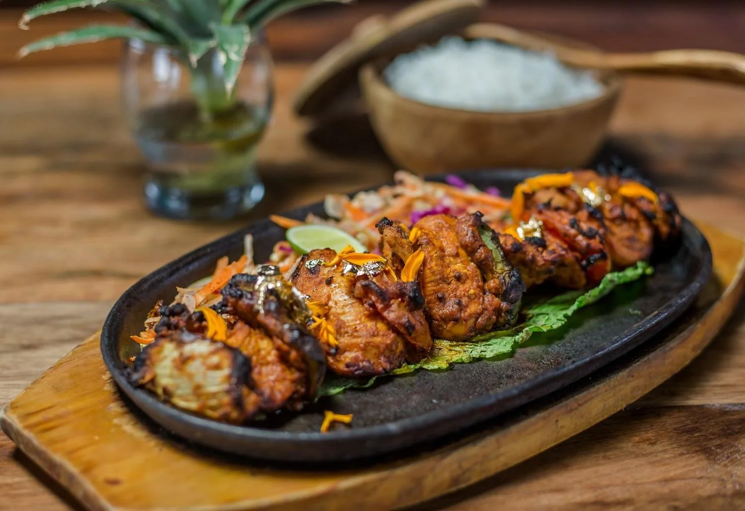 Achari Chicken served on a sizzling platter with steamed rice and fresh salad at Pesona Lounge Trawangan.