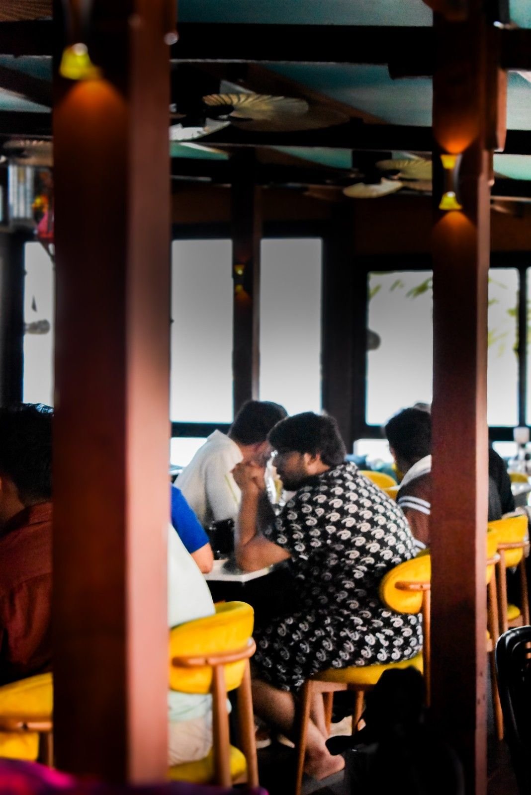 Digital nomads working and enjoying breakfast inside an air-conditioned restaurant in Gili Trawangan with spacious seating.