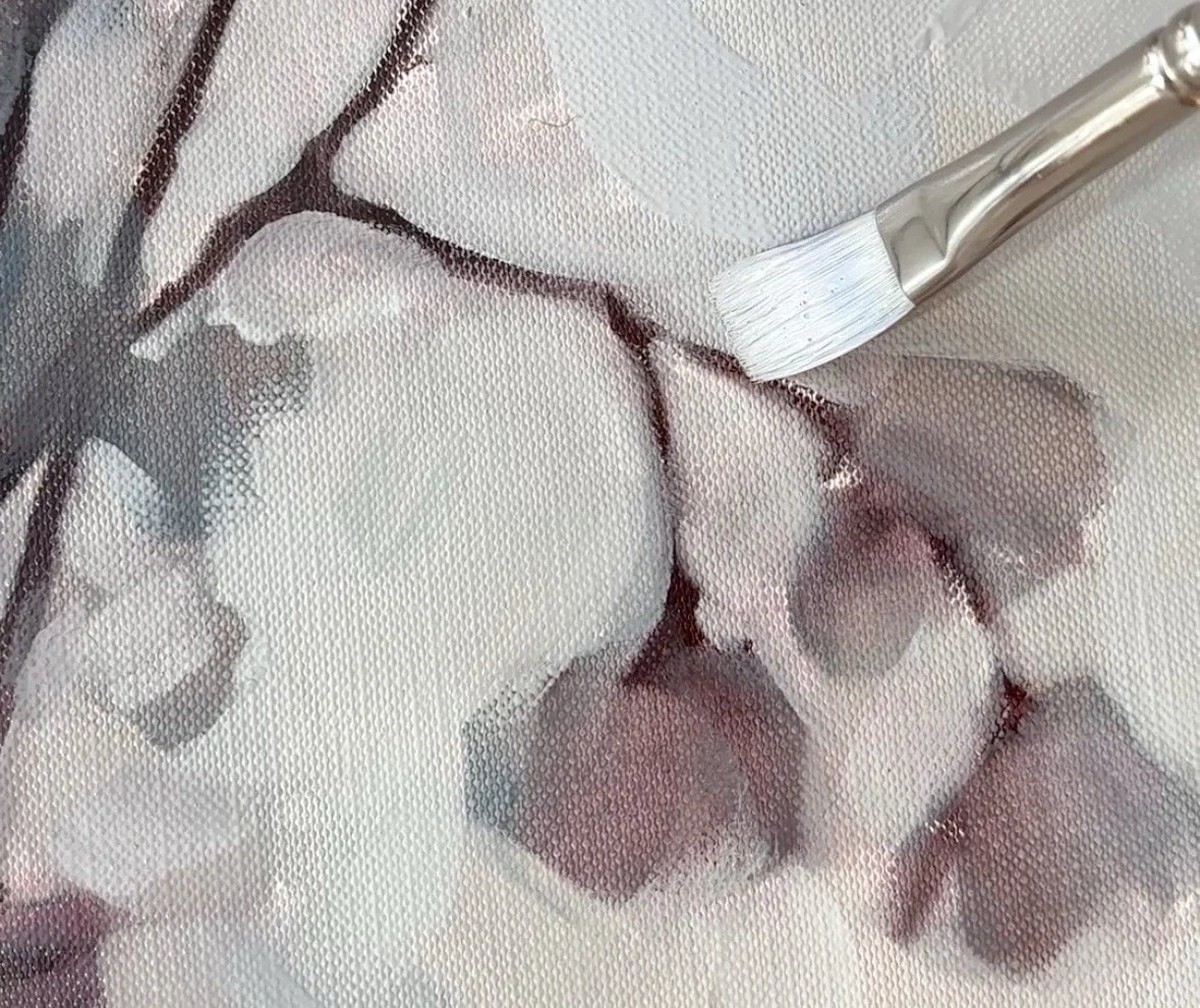 Painting cotton pads on a textured surface with a small paintbrush.