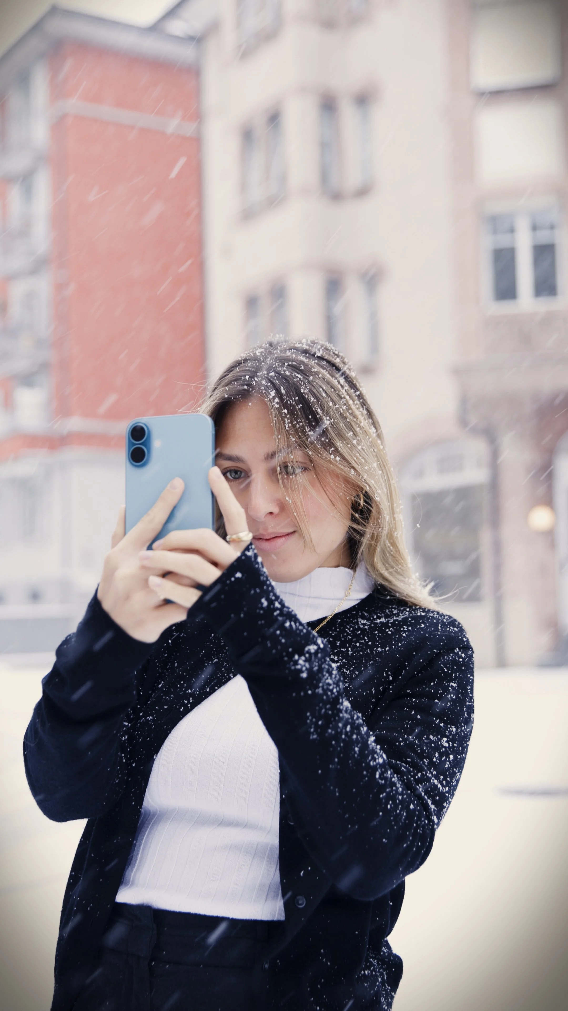 Moderner Friseursalon mit beigen Stylingstühlen um eine weiße mobile Stylingstation mit Spiegeln, weißen Wänden, Holzbalken an der Decke und großen Fenstern mit Tageslicht.