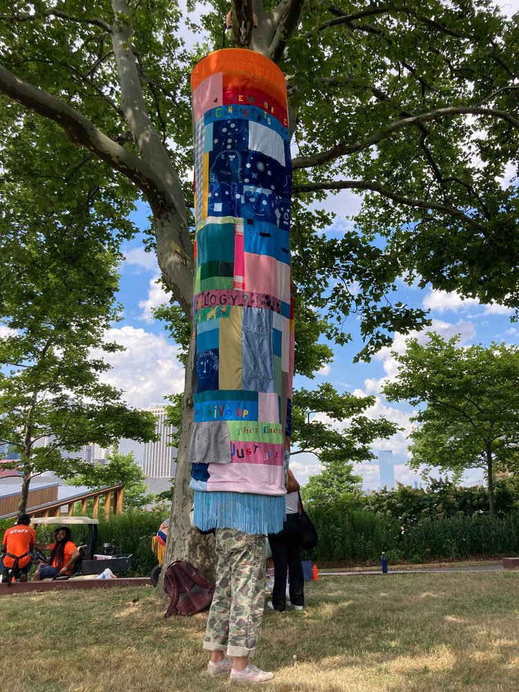 Person standing inside the Tree Chuang project. Their legs are sticking out from the bottom, and their top half is covered by the project.