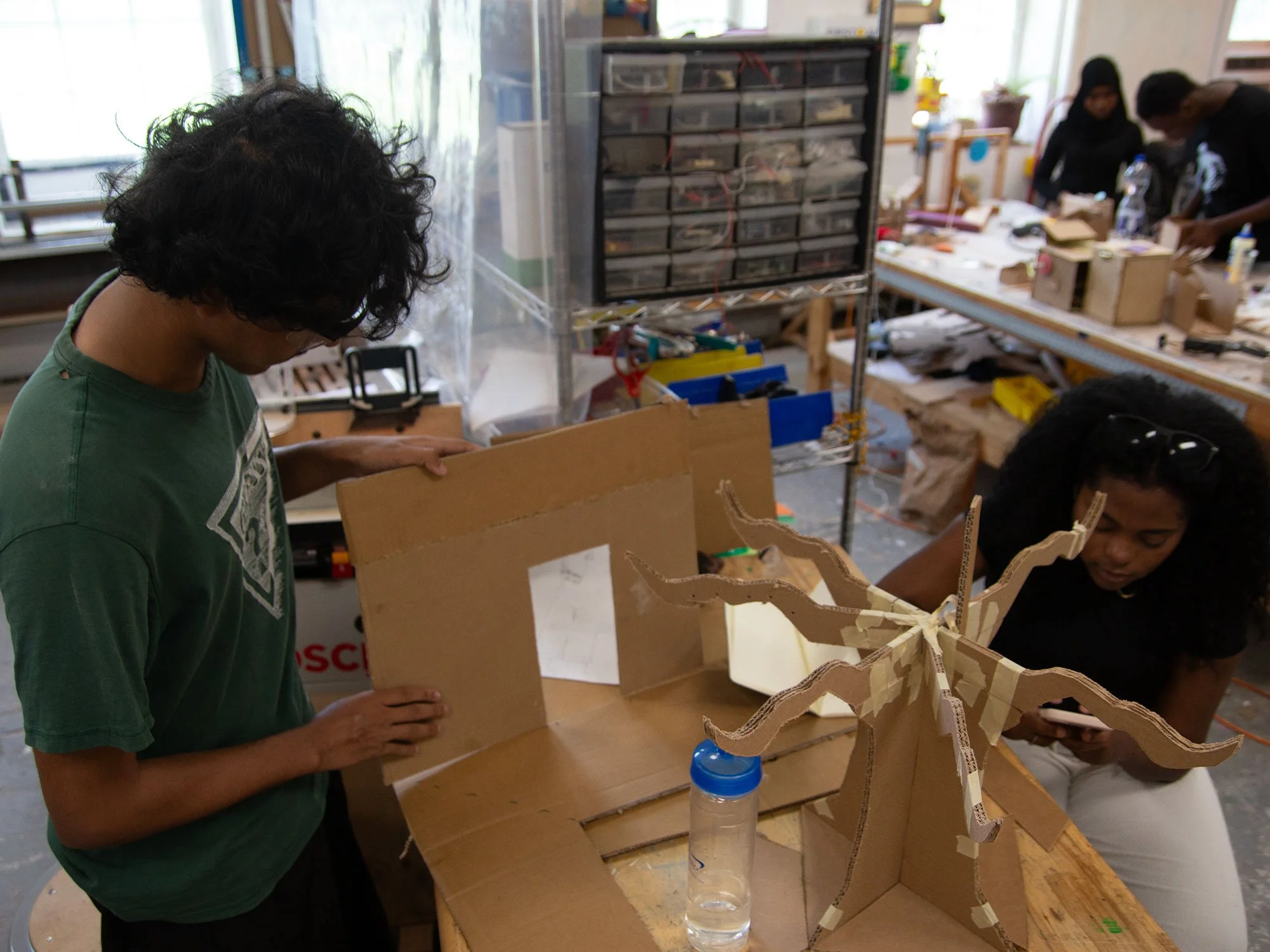Students constructing a tree out of cardboard
