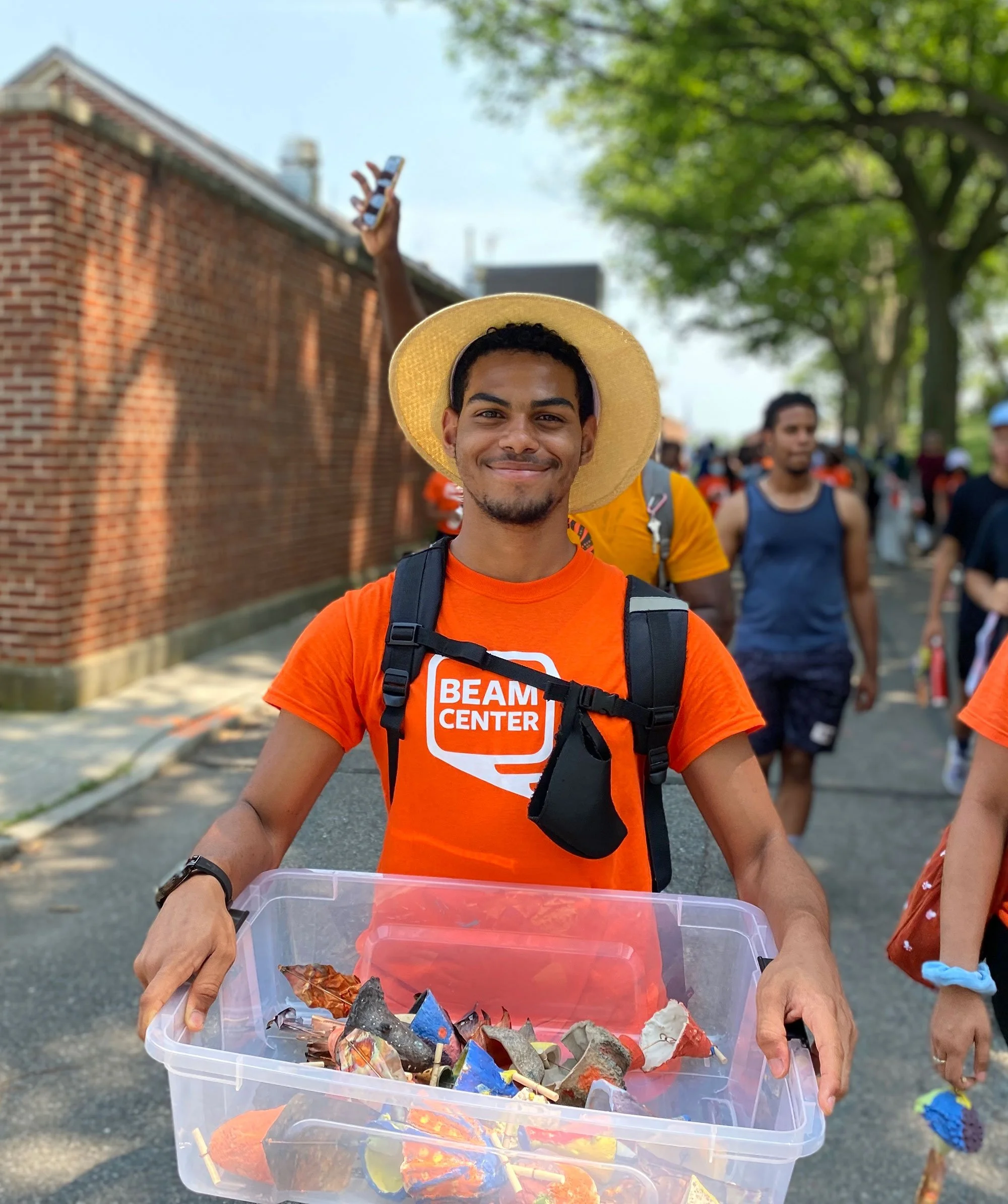 Beam Camp City project leader holding a bin while smiling at the camera