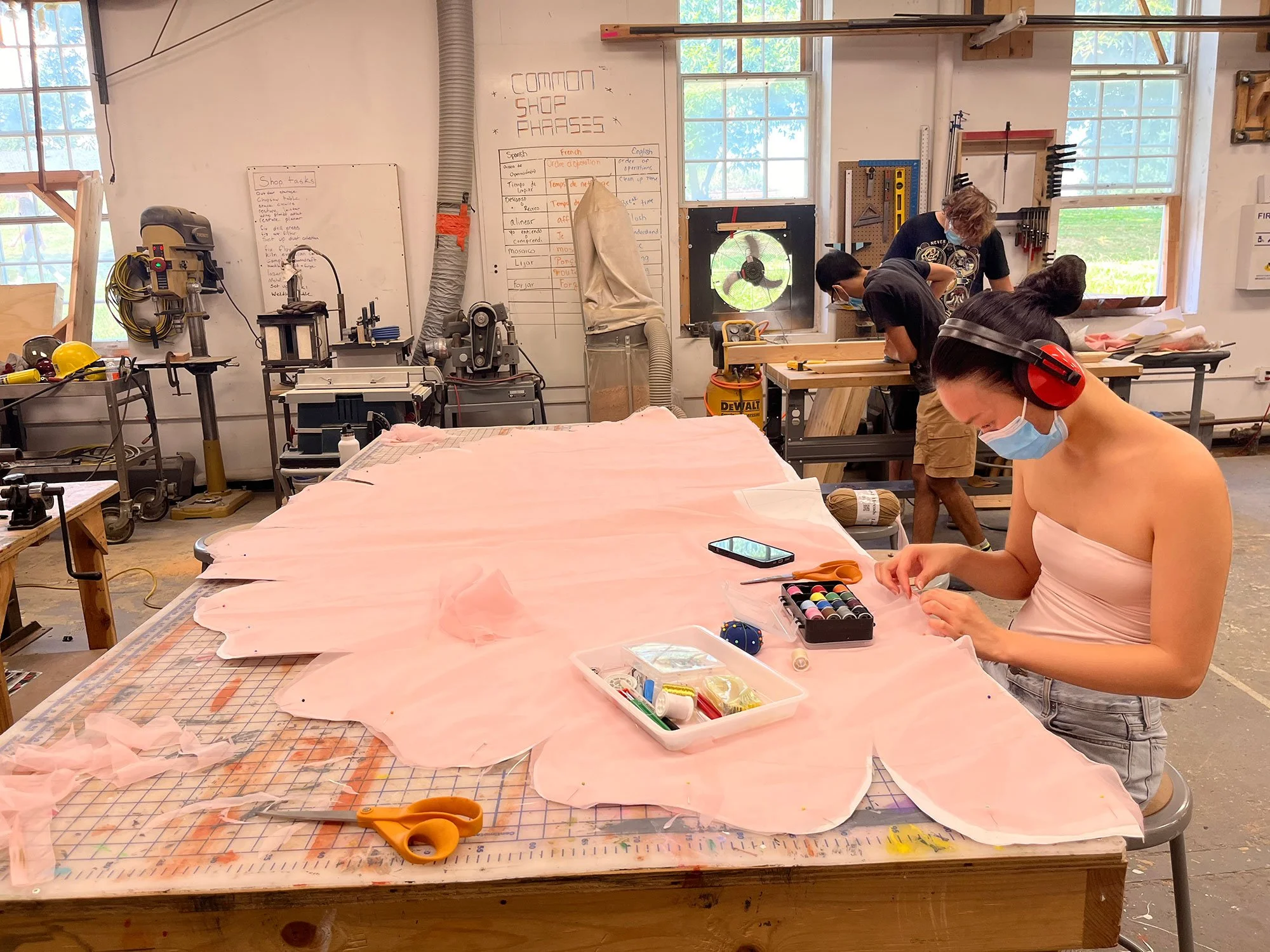 Student working at a table on OtherWorlds Fair's 2024 Big Bloom project