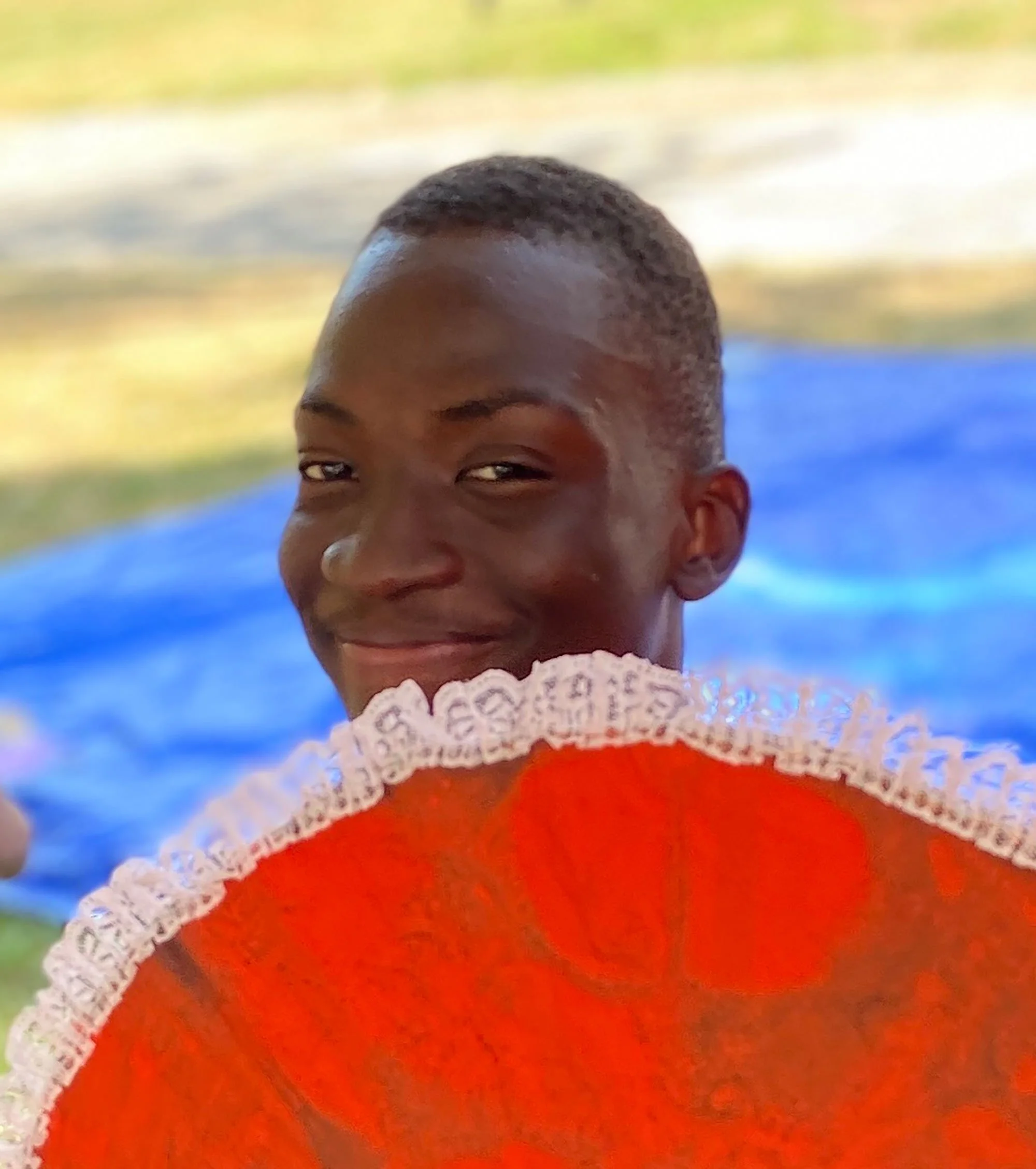 Moubarak holding a red fan and smiling
