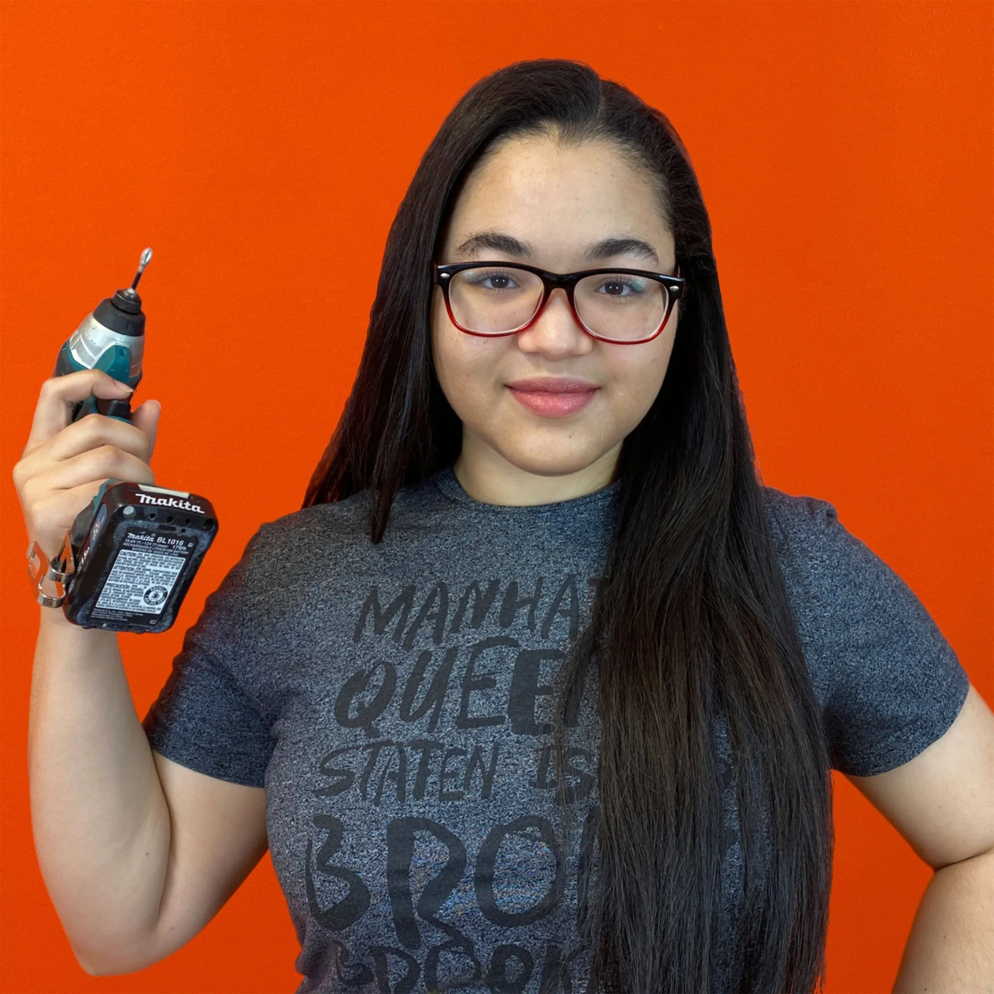 Beam Center Program Assistant Yaldiri holding a power drill in front of an orange background