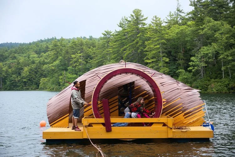 Wooden boat with water wheel being spun by young campers