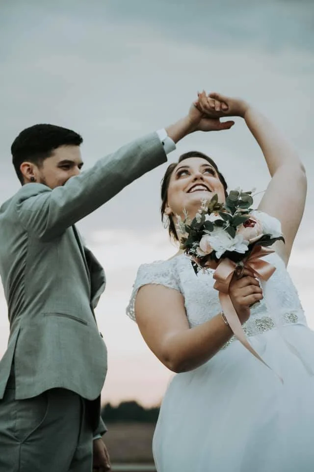 groom-spinning-bride-smiling-outdoors-cloudy-winter.jpg