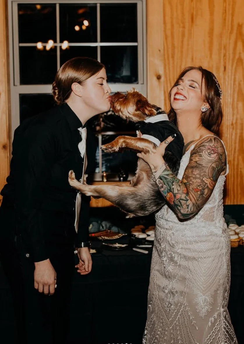 lgbtq-couple-holding-yorkie-smiling.jpg