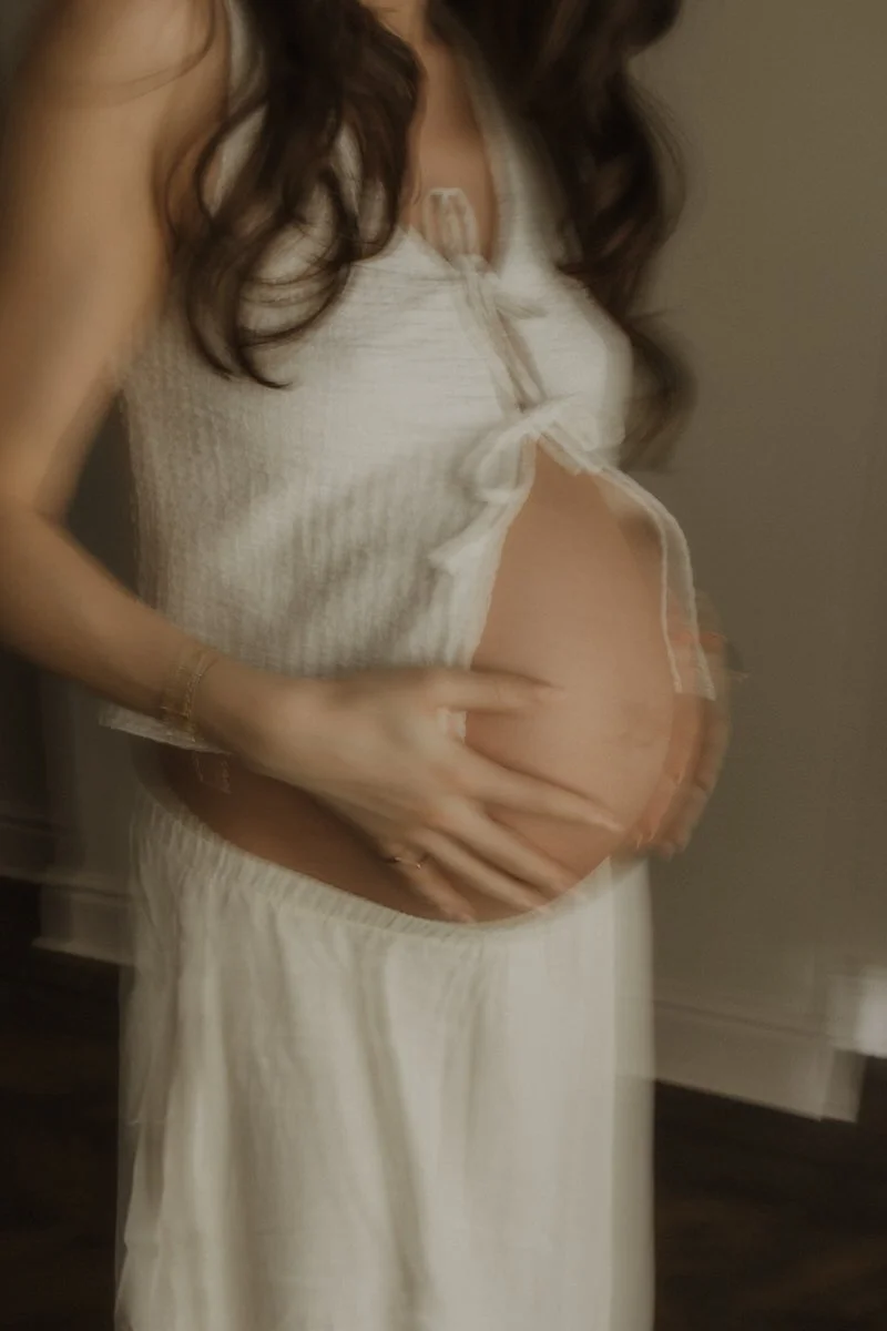 A pregnant woman holding her belly.
