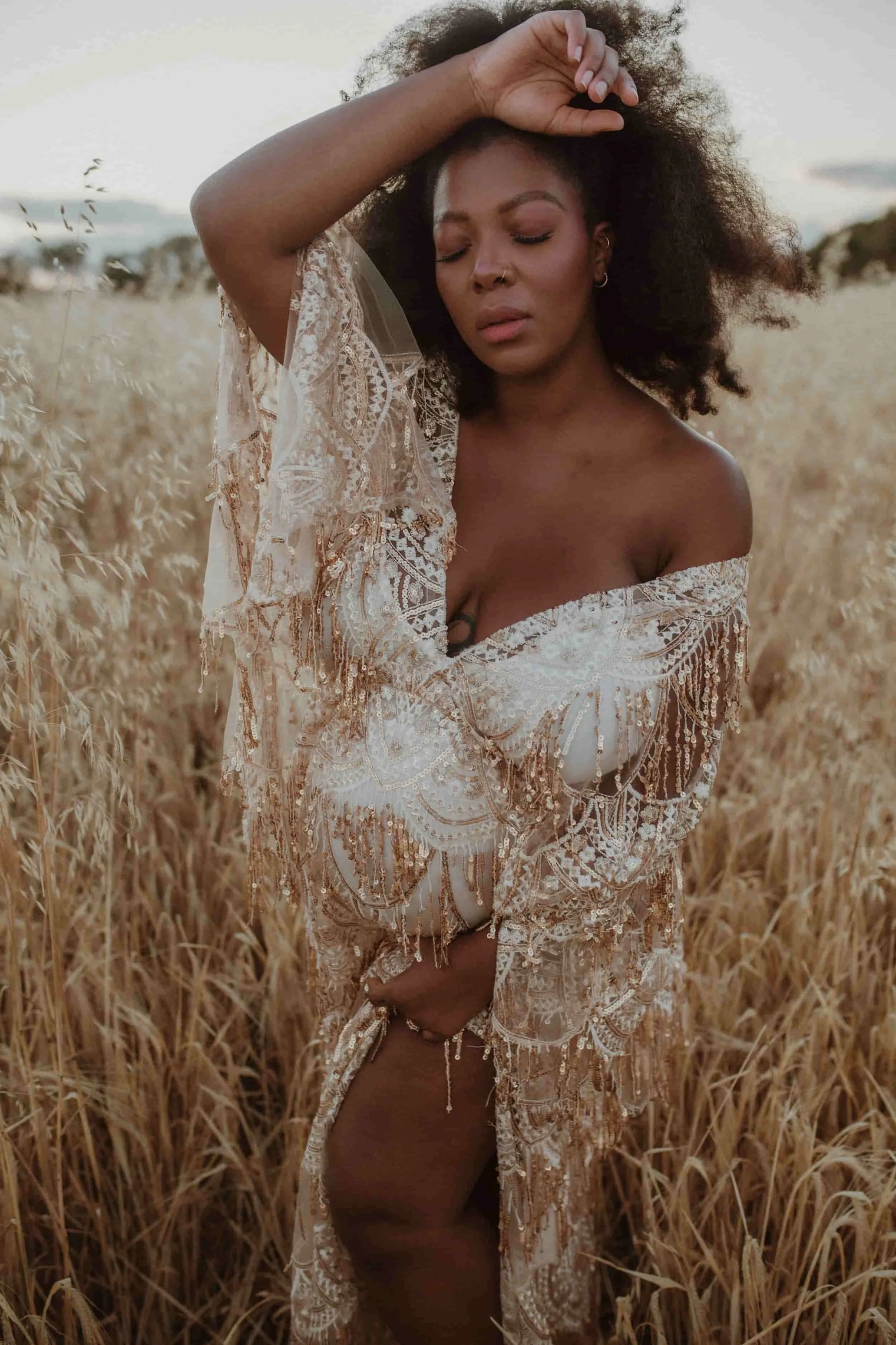 colour image of a woman in a gold dress in a field