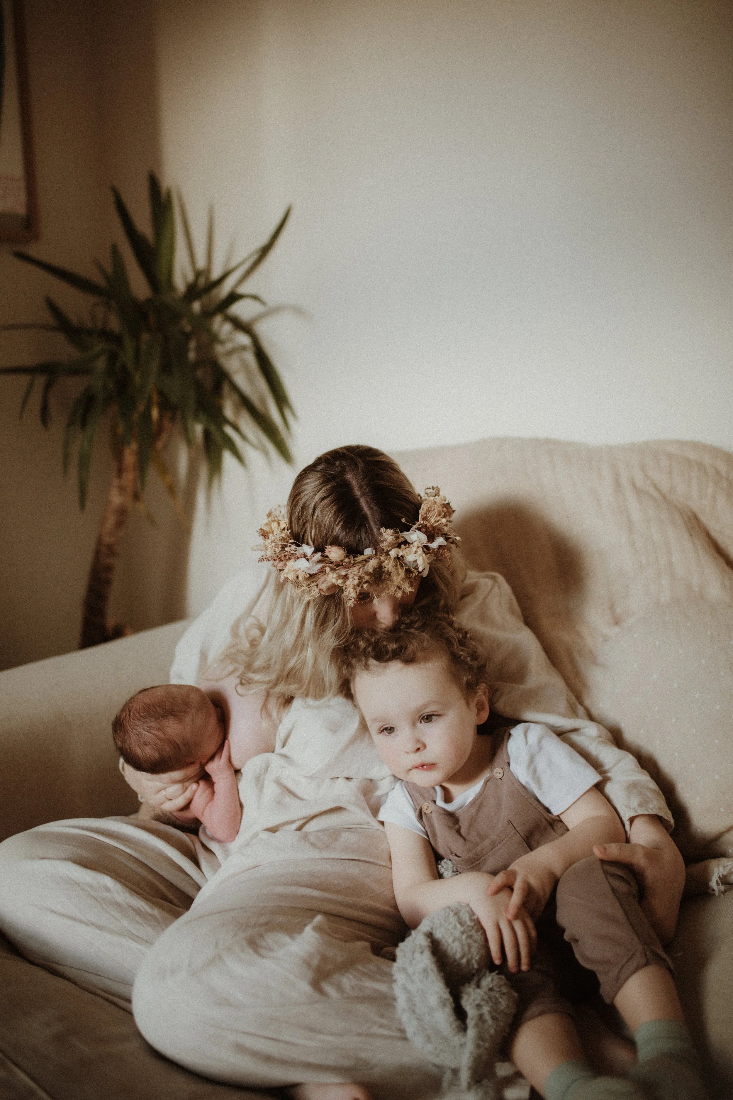 mother sitting with children on the sofa newborn photography in Hitchin